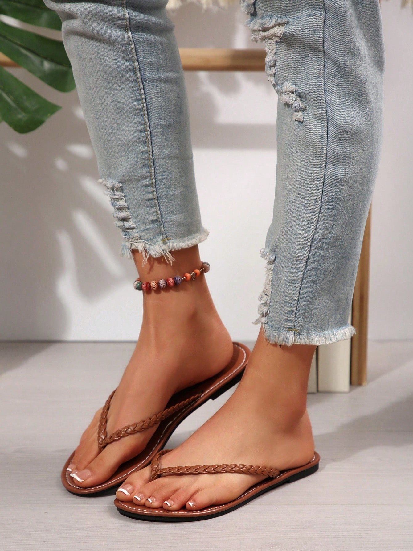 Women's chocolate brown flat flip flop sandals featuring a toe-post thong style and braided detail, suitable for casual indoor and outdoor wear.