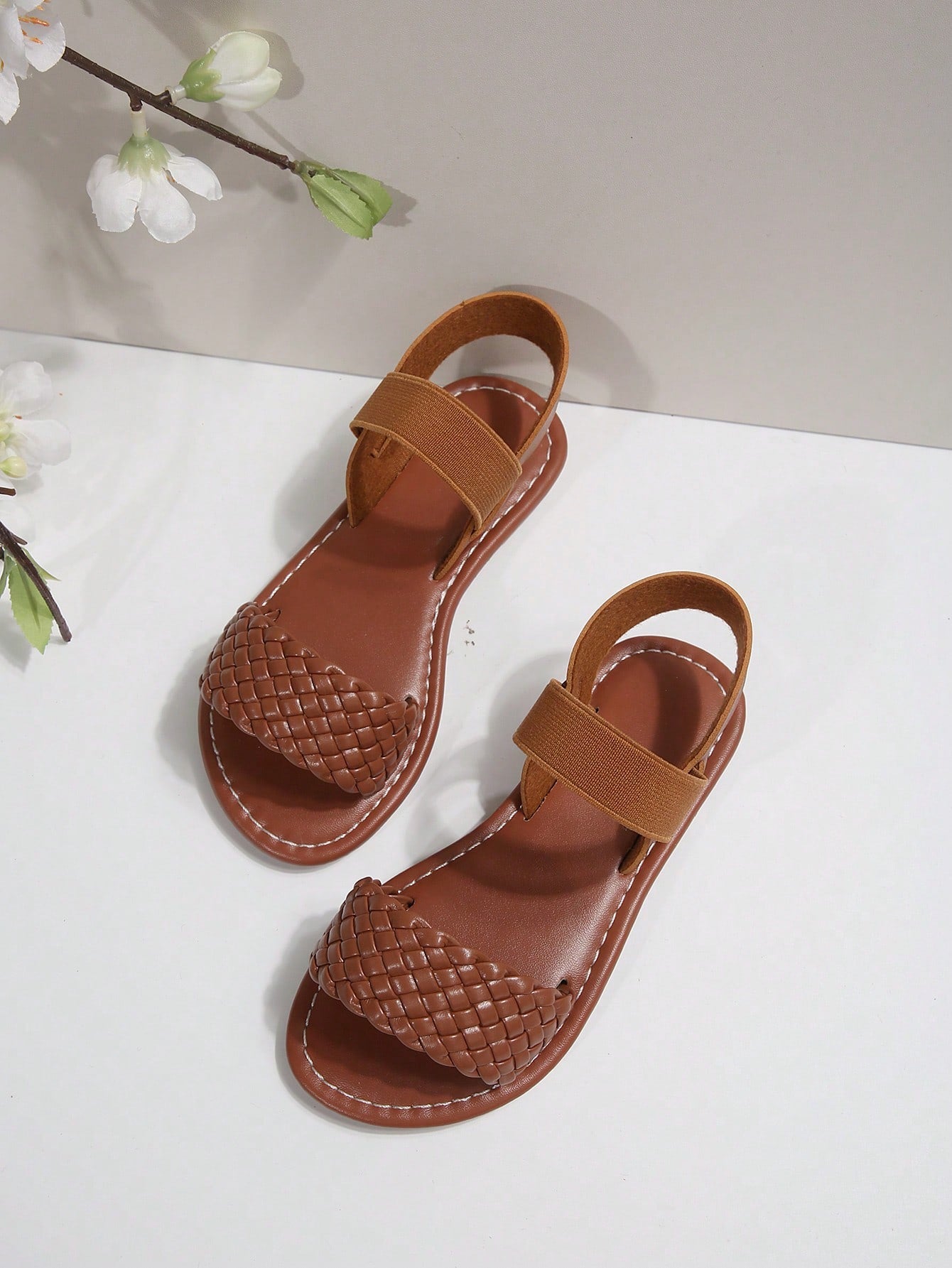 Women’s flat slide sandals with cut-out Roman-style straps and open-toe design, suitable for casual beach and home wear.