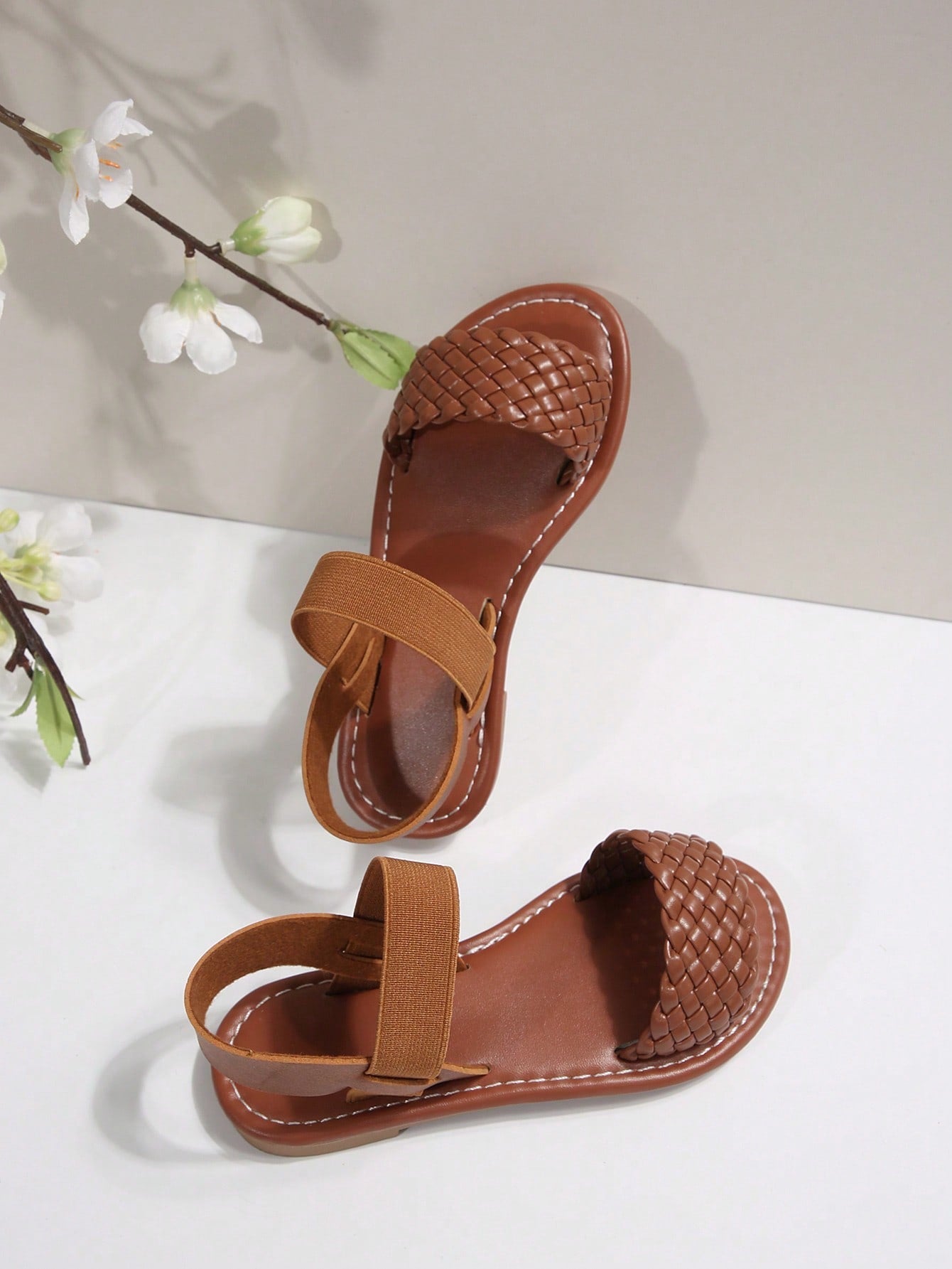 Women’s flat slide sandals with cut-out Roman-style straps and open-toe design, suitable for casual beach and home wear.