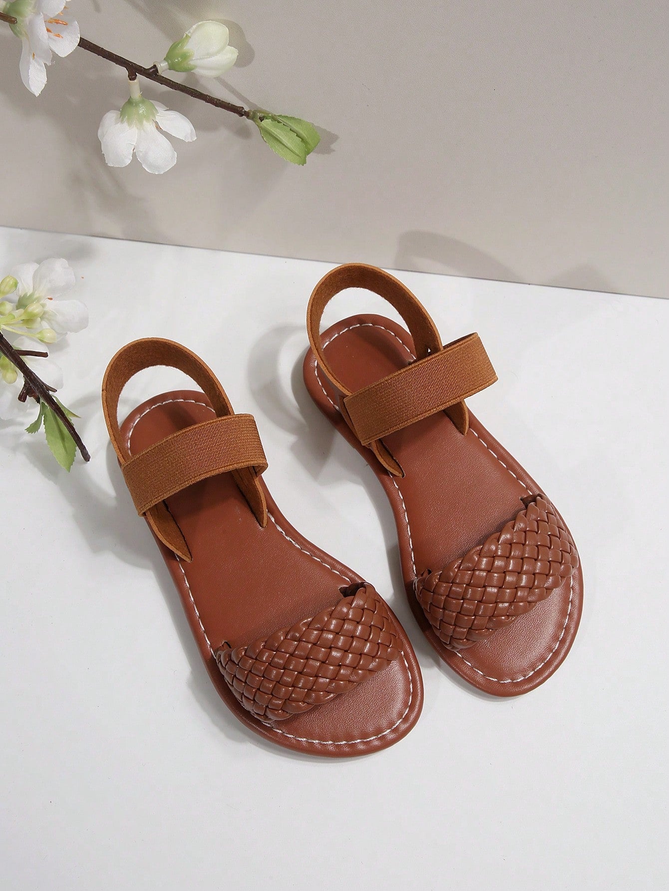 Women’s flat slide sandals with cut-out Roman-style straps and open-toe design, suitable for casual beach and home wear.