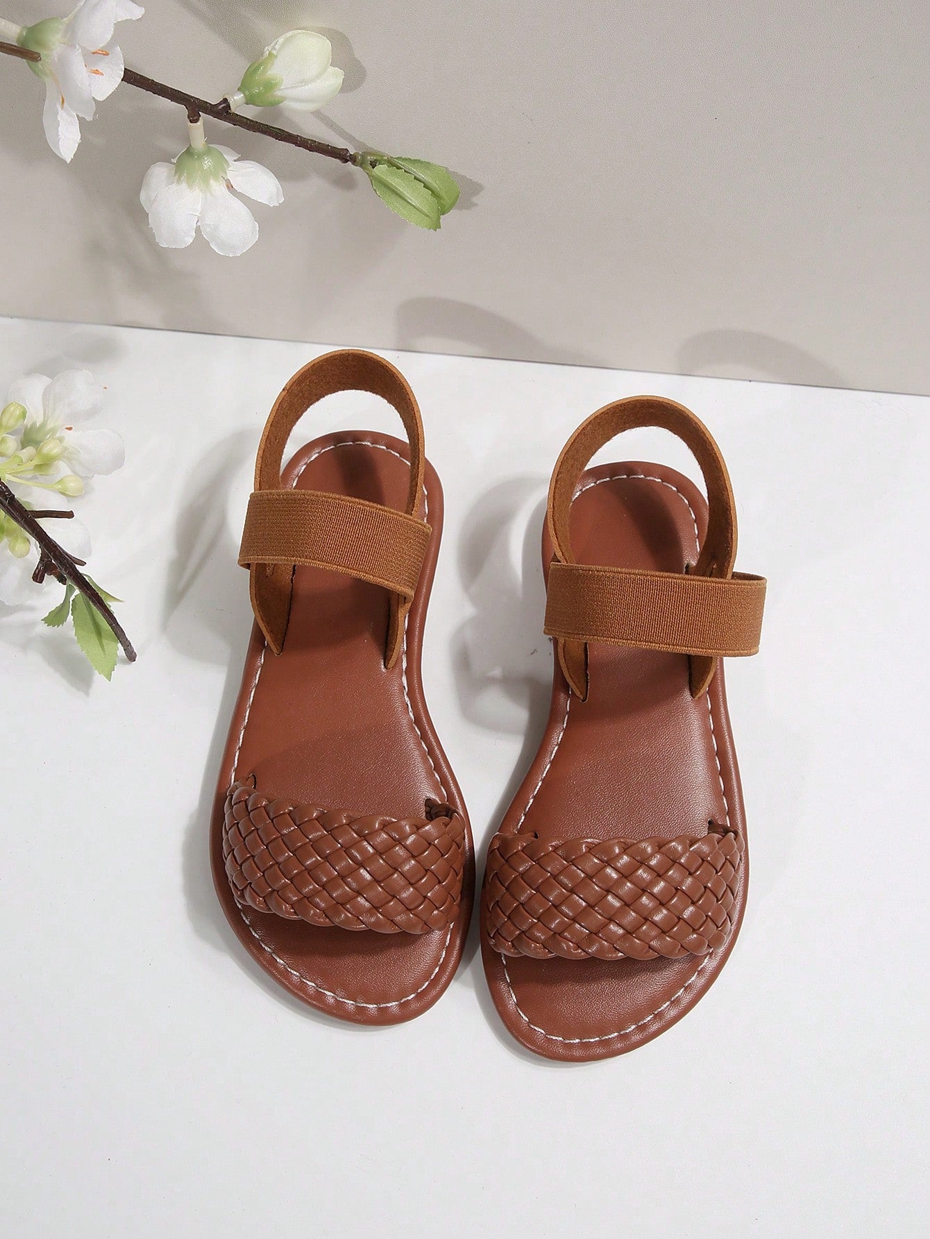 Women’s flat slide sandals with cut-out Roman-style straps and open-toe design, suitable for casual beach and home wear.