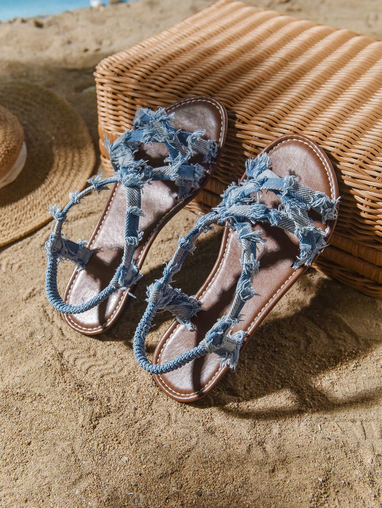 Plus size women's blue slip-on flat gladiator sandals with criss cross straps and open toe, shown in a casual beach style for spring and summer outfits.