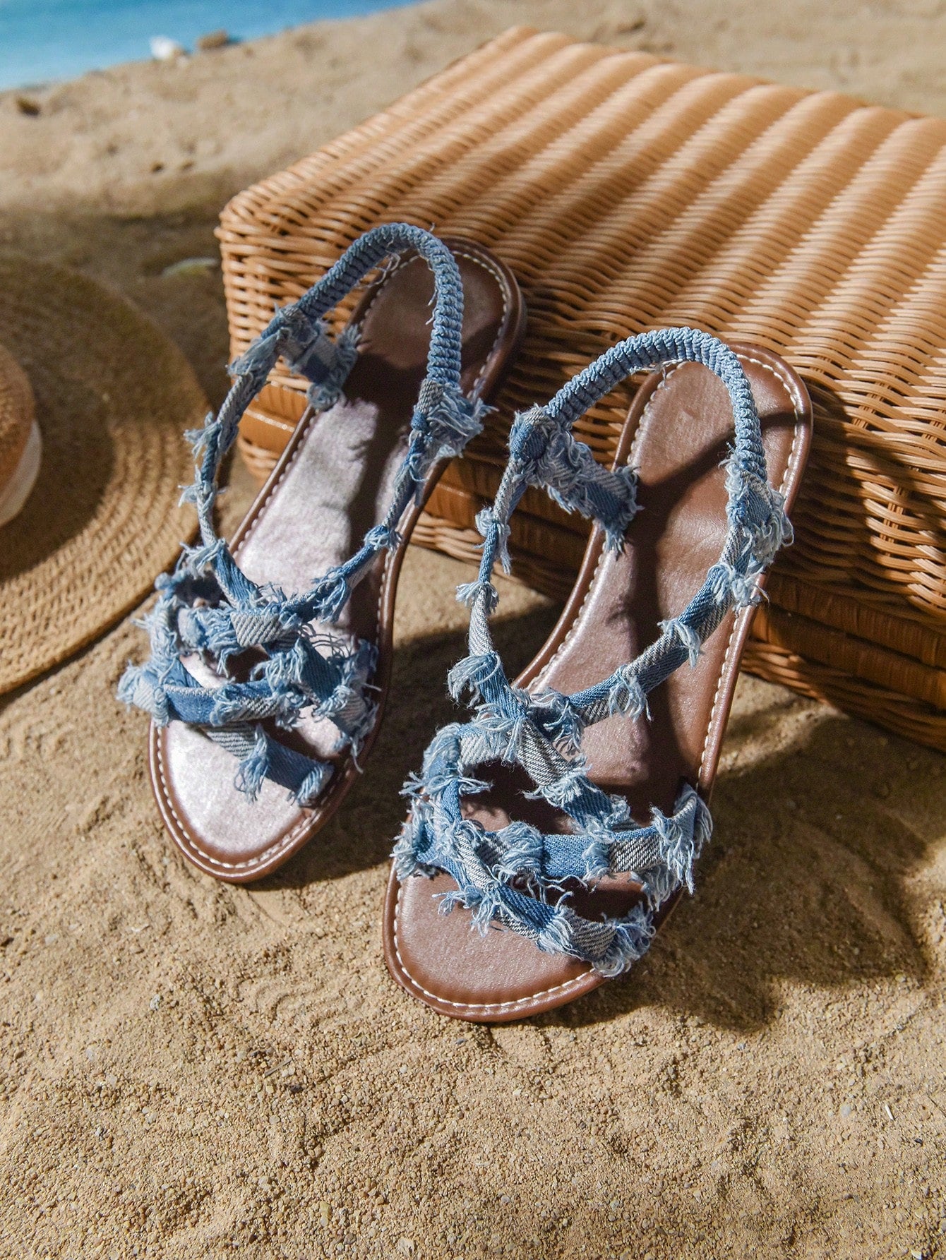 Plus size women's blue slip-on flat gladiator sandals with criss cross straps and open toe, shown in a casual beach style for spring and summer outfits.