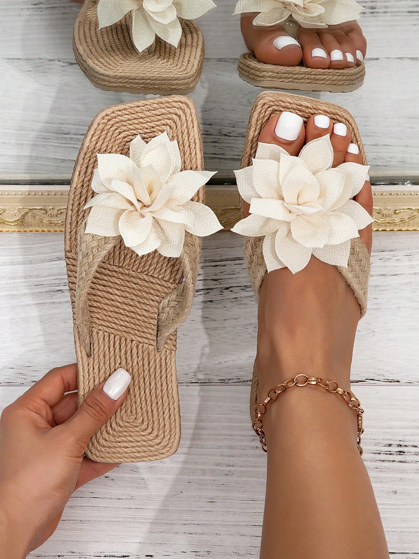 Women’s flat linen flip-flops with flower appliqué decor and sole, beach slipper style.