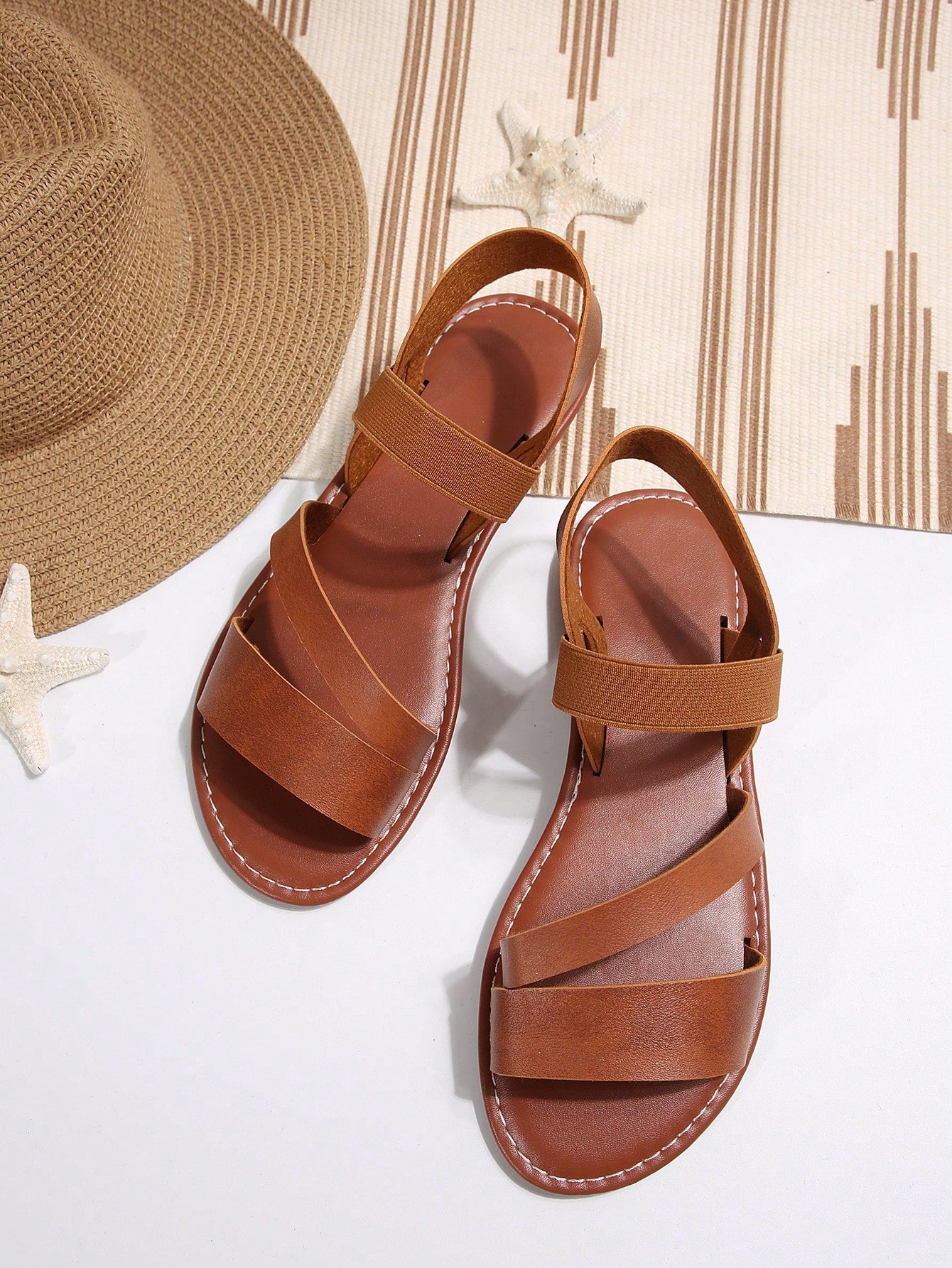 Women’s flat slide sandals with cut-out Roman-style straps and open-toe design, suitable for casual beach and home wear.