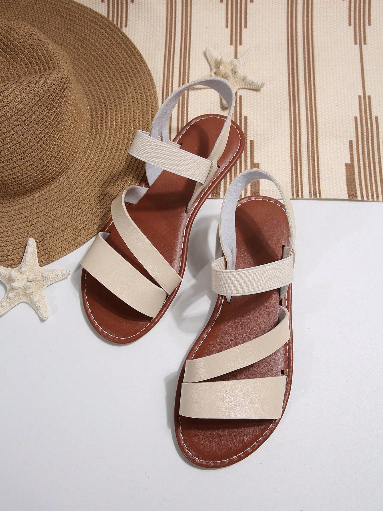 Women’s flat slide sandals with cut-out Roman-style straps and open-toe design, suitable for casual beach and home wear.