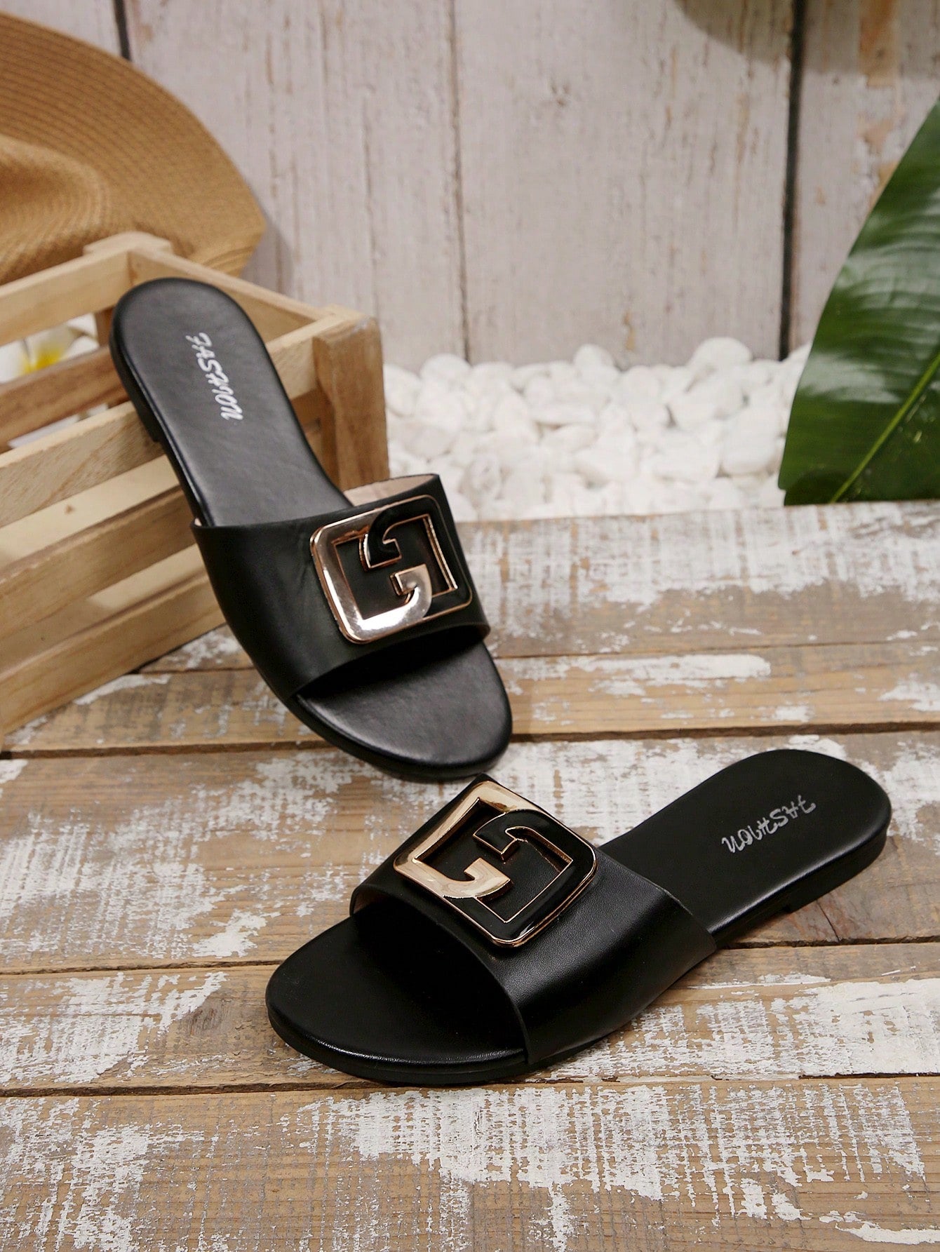 Pair of women's black flat slide sandals featuring rhinestone embellishments, metal accents, and a gold-strip detail on the upper, with an open-toe slip-on design.