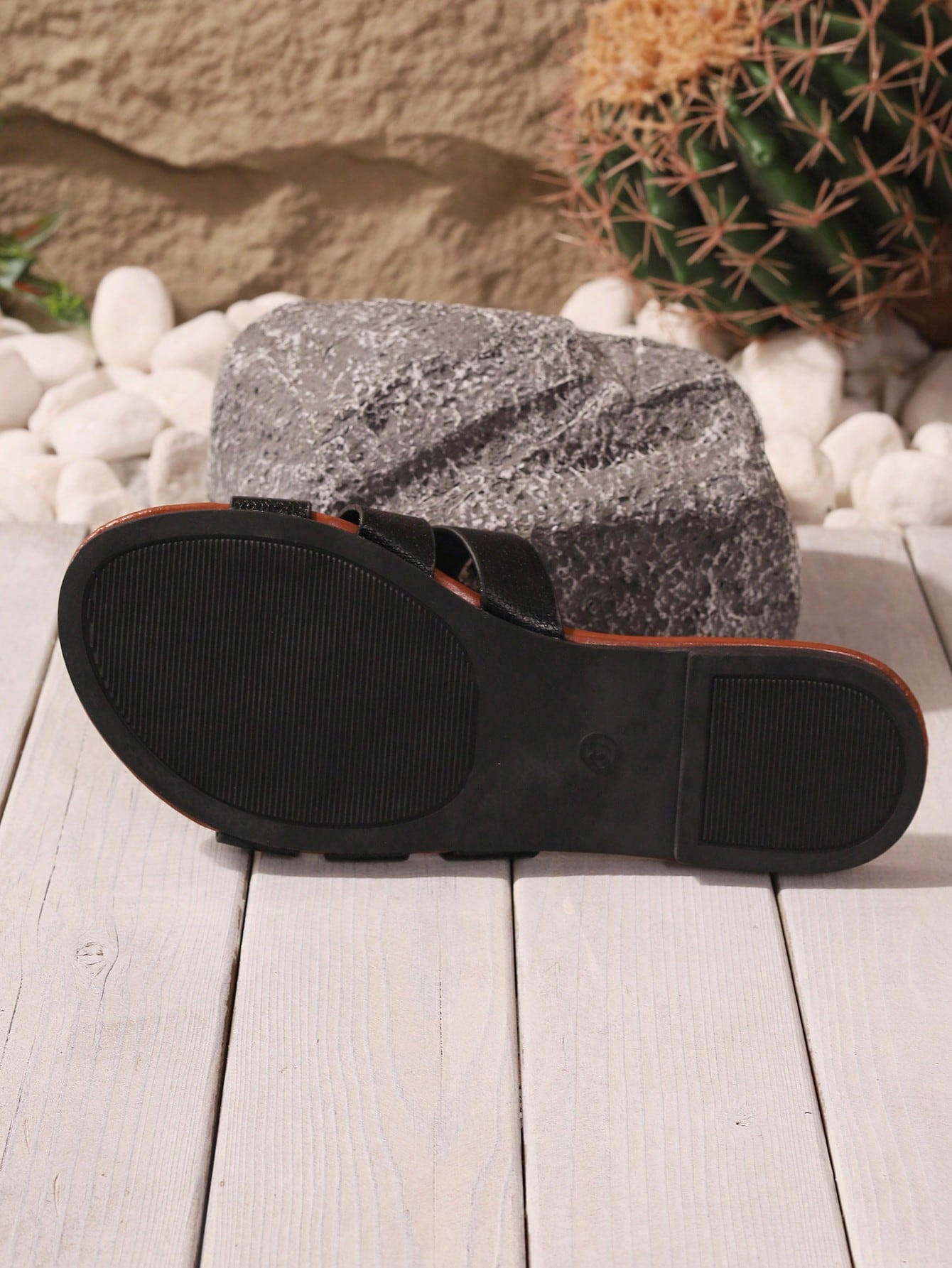 Pair of women's black flat slide sandals with open toes and cut-out detailing in a beach style.