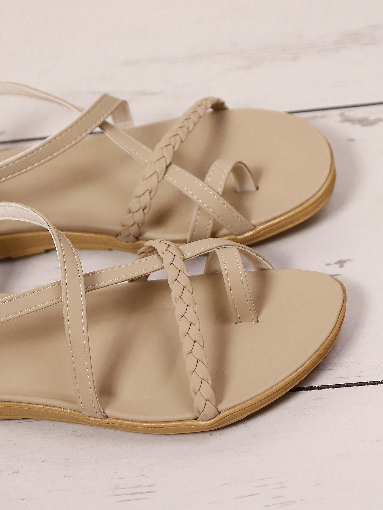 Women's beige flat sandals with criss cross straps, ankle strap, and open toe.