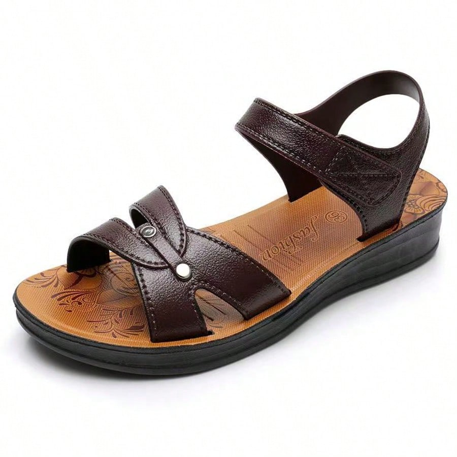 Women's brown flat slide sandals with hollow-out breathable upper and hook-and-loop closure, designed for casual outdoor and beach wear.
