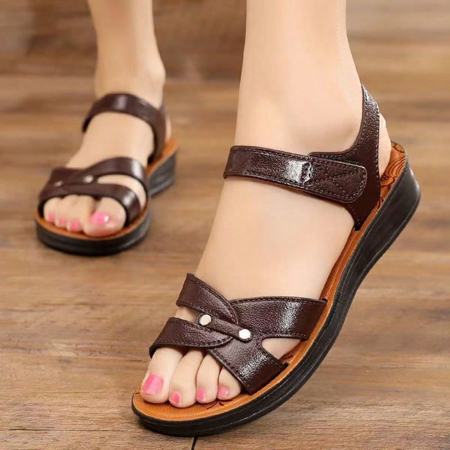 Women's brown flat slide sandals with hollow-out breathable upper and hook-and-loop closure, designed for casual outdoor and beach wear.