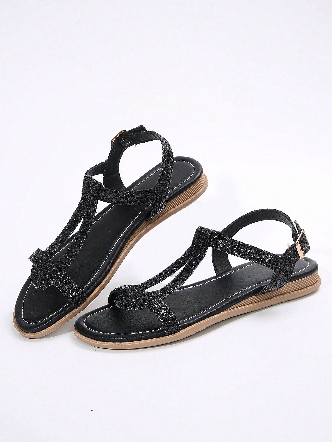 Women’s flat sandals with multiple straps, open toe front, and ankle strap buckle, featuring a plain design with glitter accents in a beach vacation style.