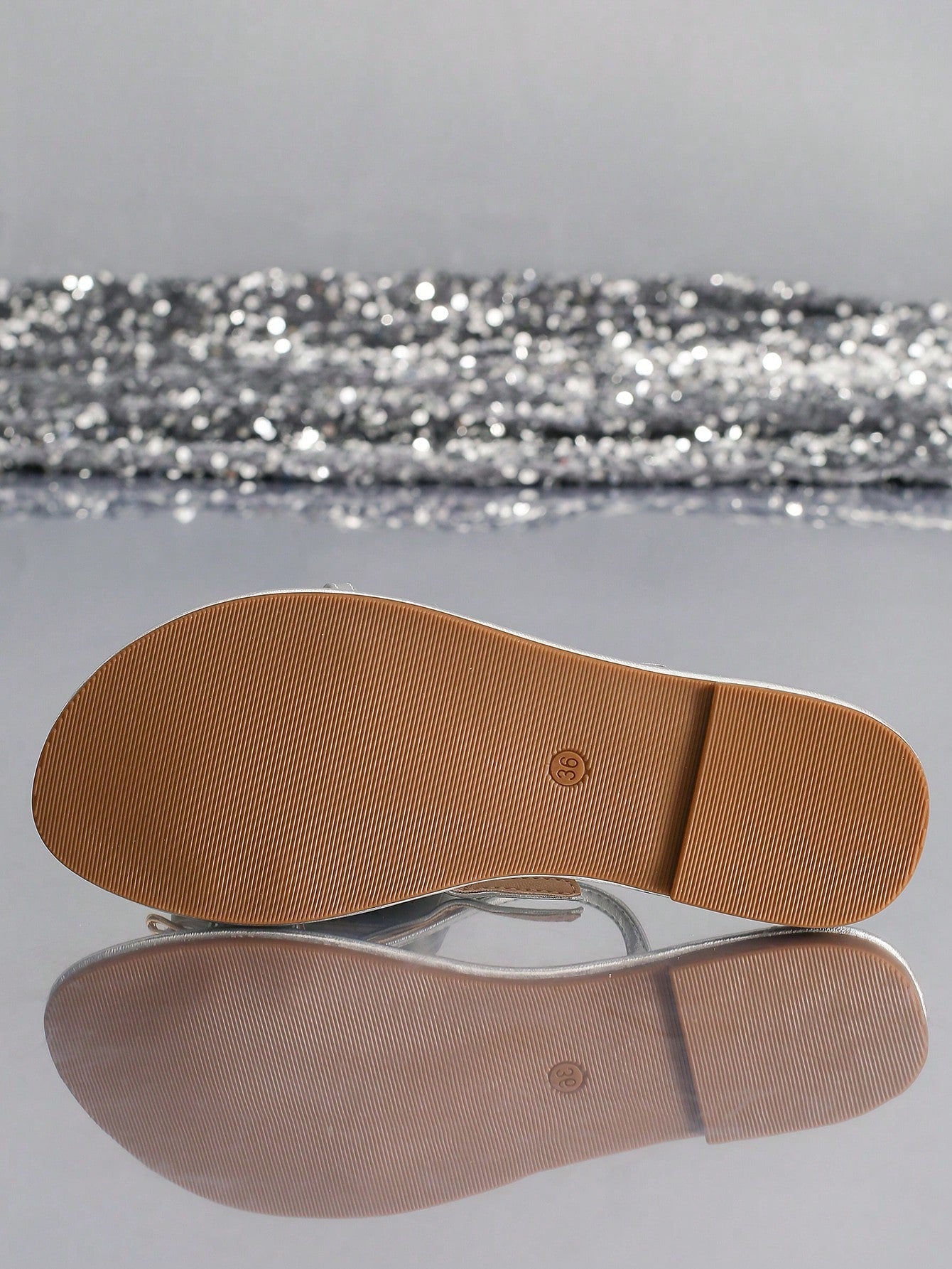 Women's slip-on flat sandals featuring round toe styling, a toe post, metal strap detail, and buckle accent, designed for casual beach and warm-weather outfits.