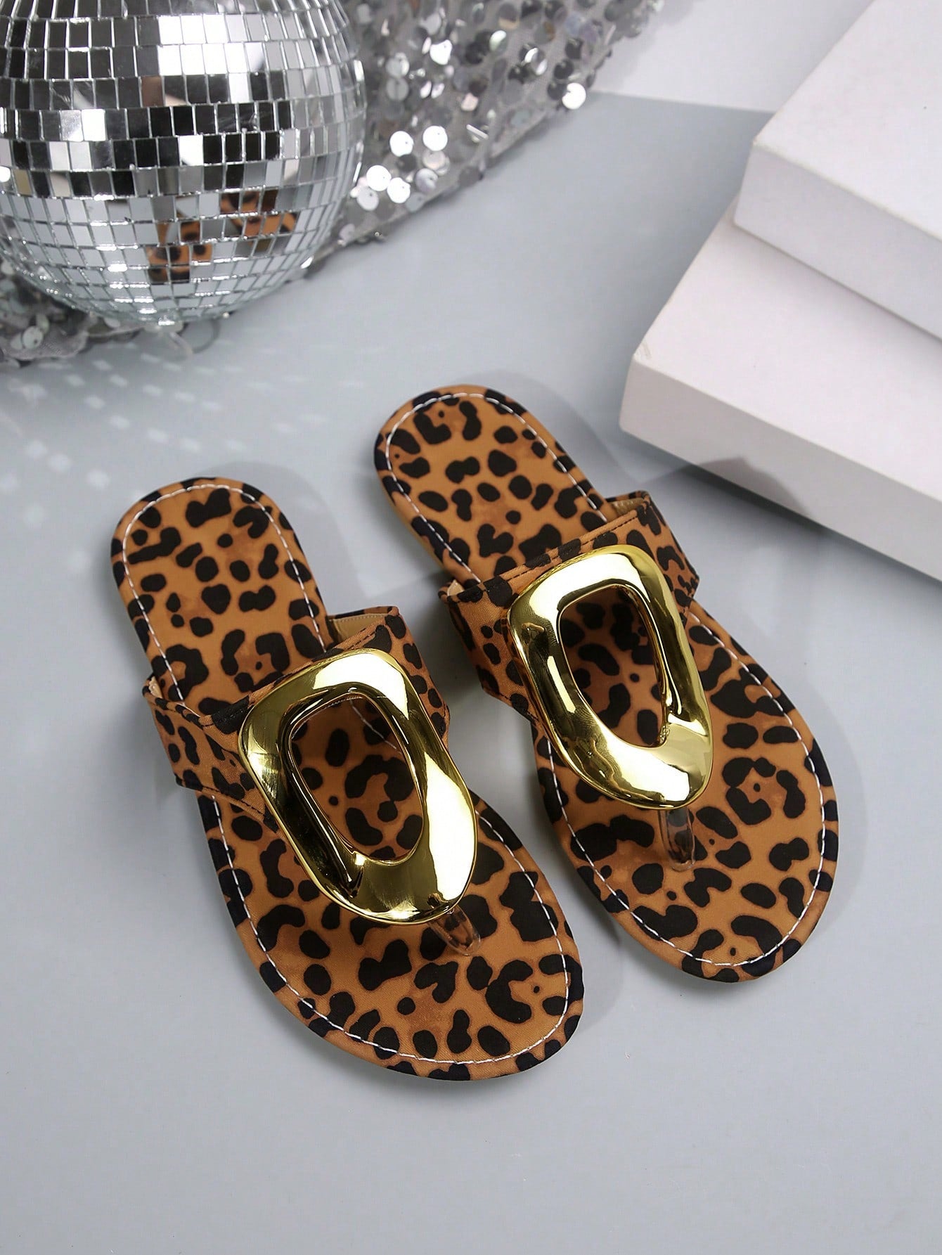 Women's leopard print slip-on flat slide sandals with metal buckle decor, fabric upper, and open slide design for outdoor wear.