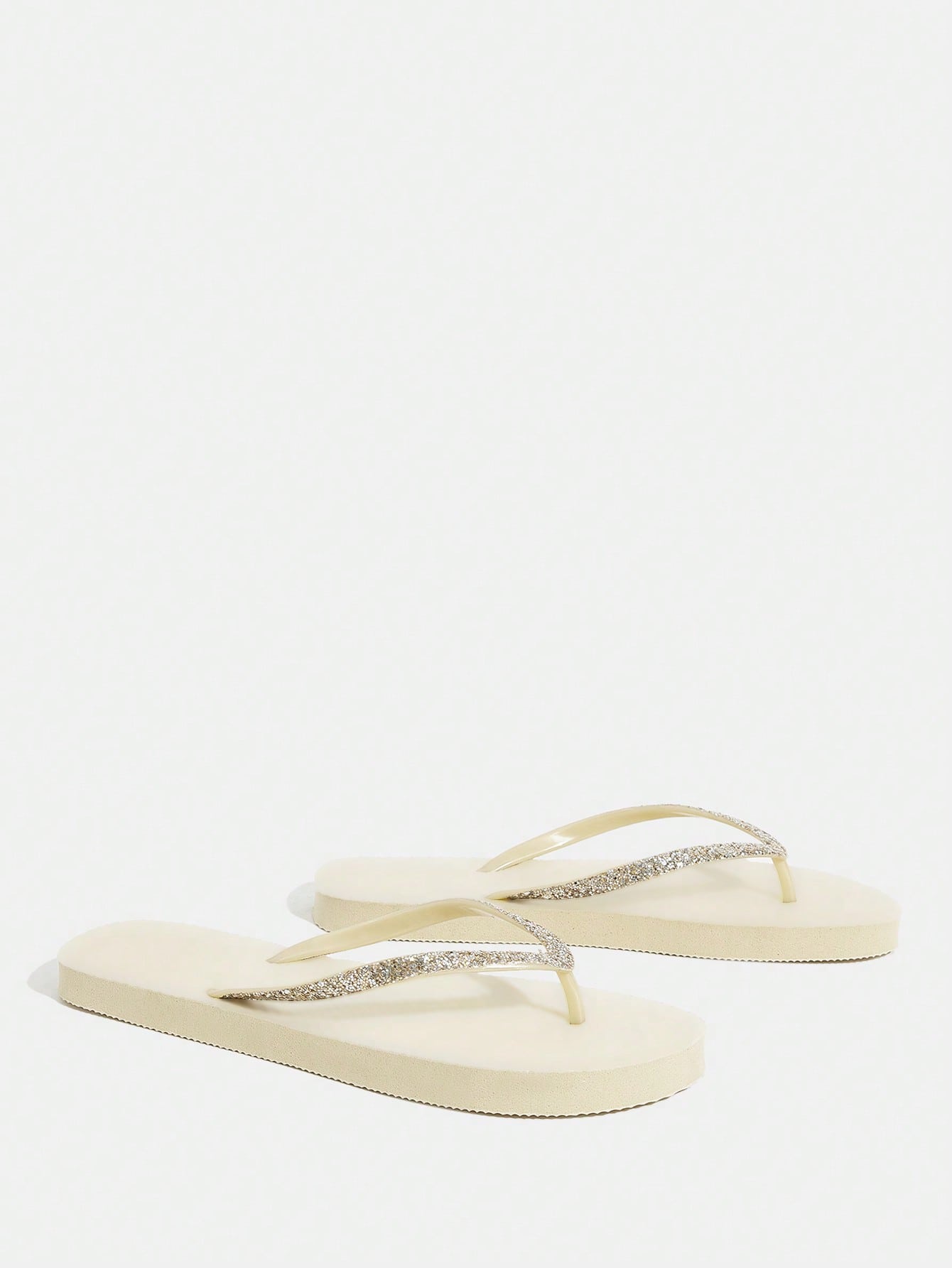Pair of women’s apricot flat flip-flops with a glitter upper and plain design, suitable for beach, outdoor, home, and vacation wear.