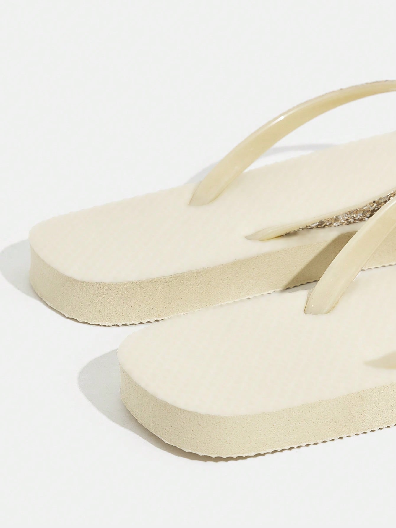 Pair of women’s apricot flat flip-flops with a glitter upper and plain design, suitable for beach, outdoor, home, and vacation wear.