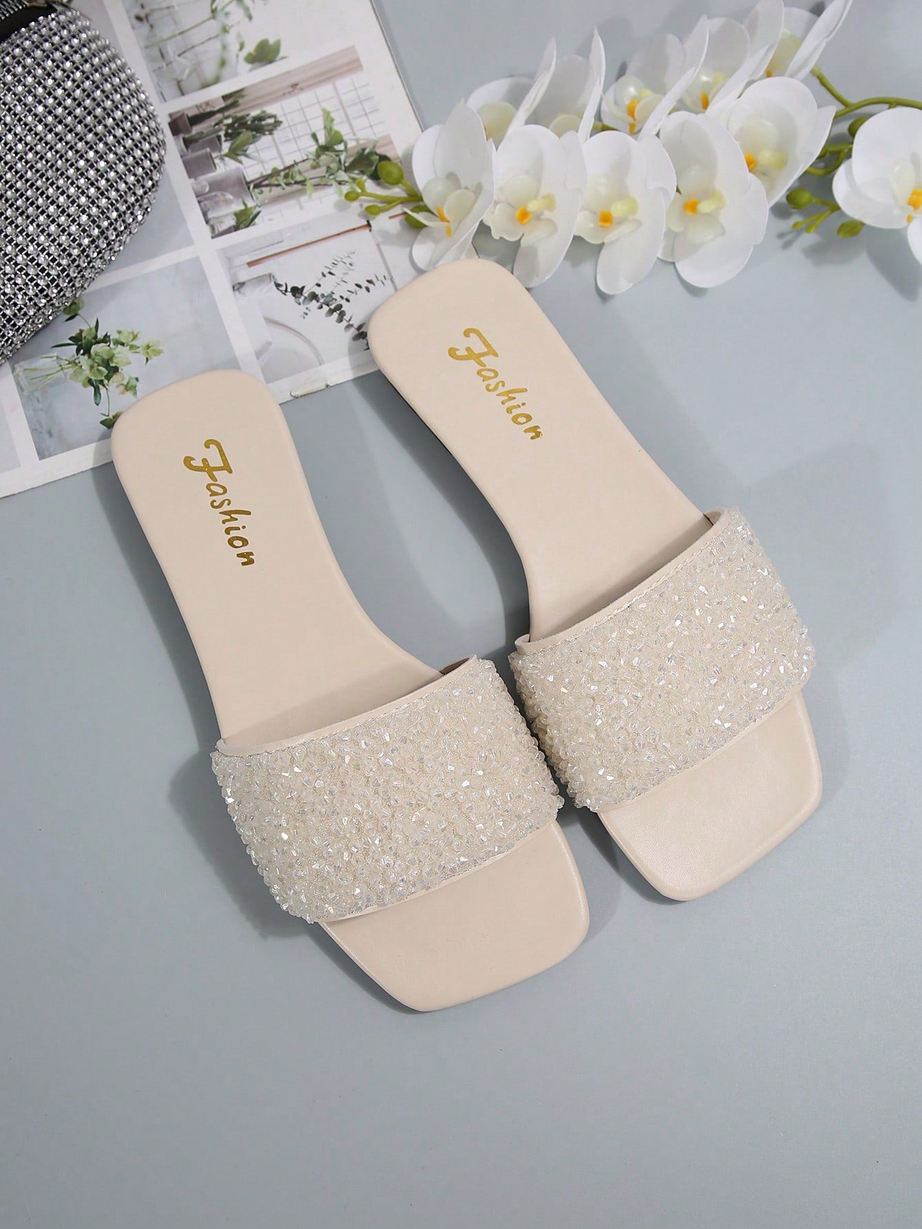Women's flat slide sandals with rhinestone-decorated straps and open toe, casual outdoor style with plain design.