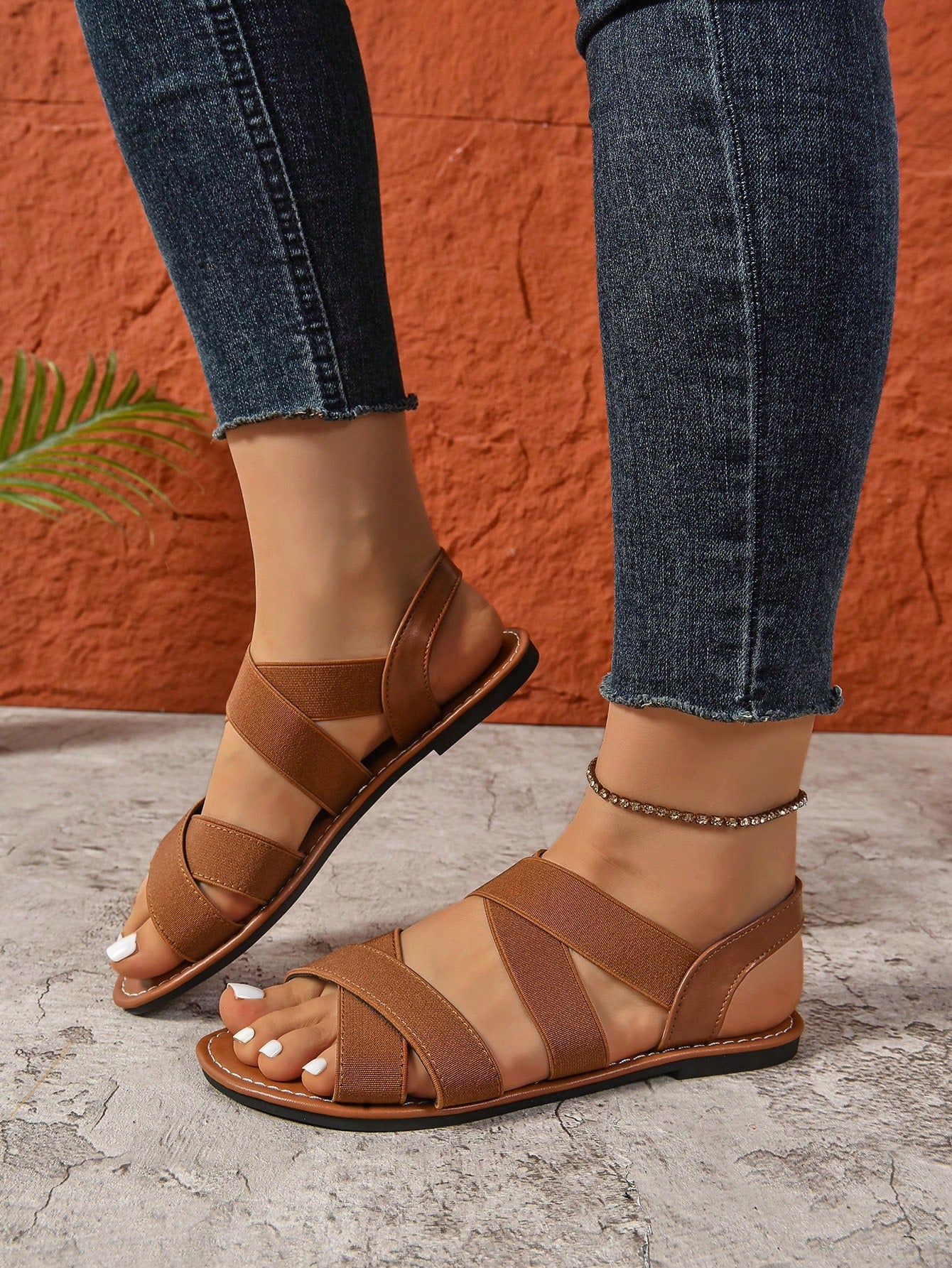 Women's wide fit flat slip-on sandals with criss-cross straps and open toe, designed for casual outdoor and beach wear.