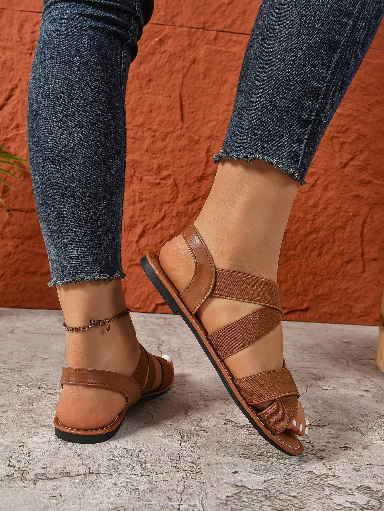 Women's wide fit flat slip-on sandals with criss-cross straps and open toe, designed for casual outdoor and beach wear.