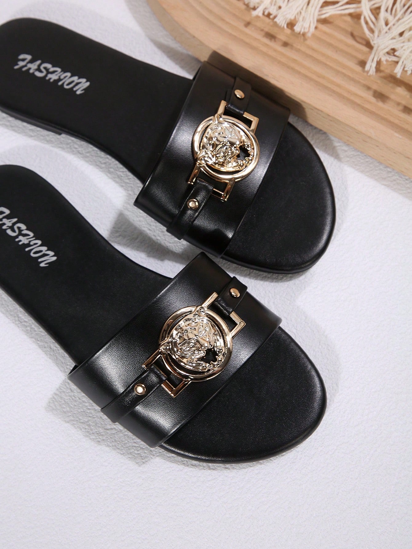 Pair of women's black flat slide sandals featuring rhinestone embellishments, metal accents, and a gold-strip detail on the upper, with an open-toe slip-on design.