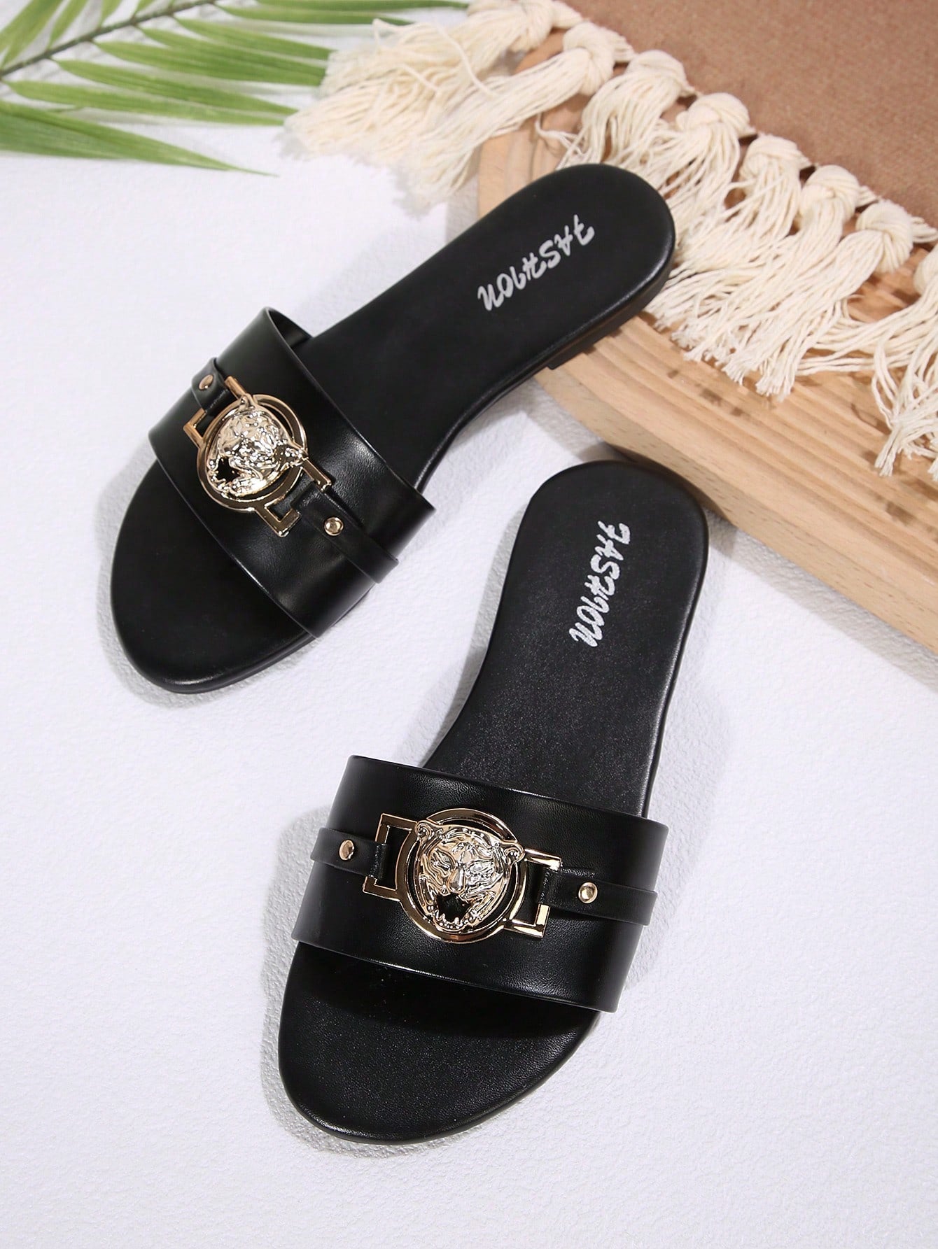 Pair of women's black flat slide sandals featuring rhinestone embellishments, metal accents, and a gold-strip detail on the upper, with an open-toe slip-on design.