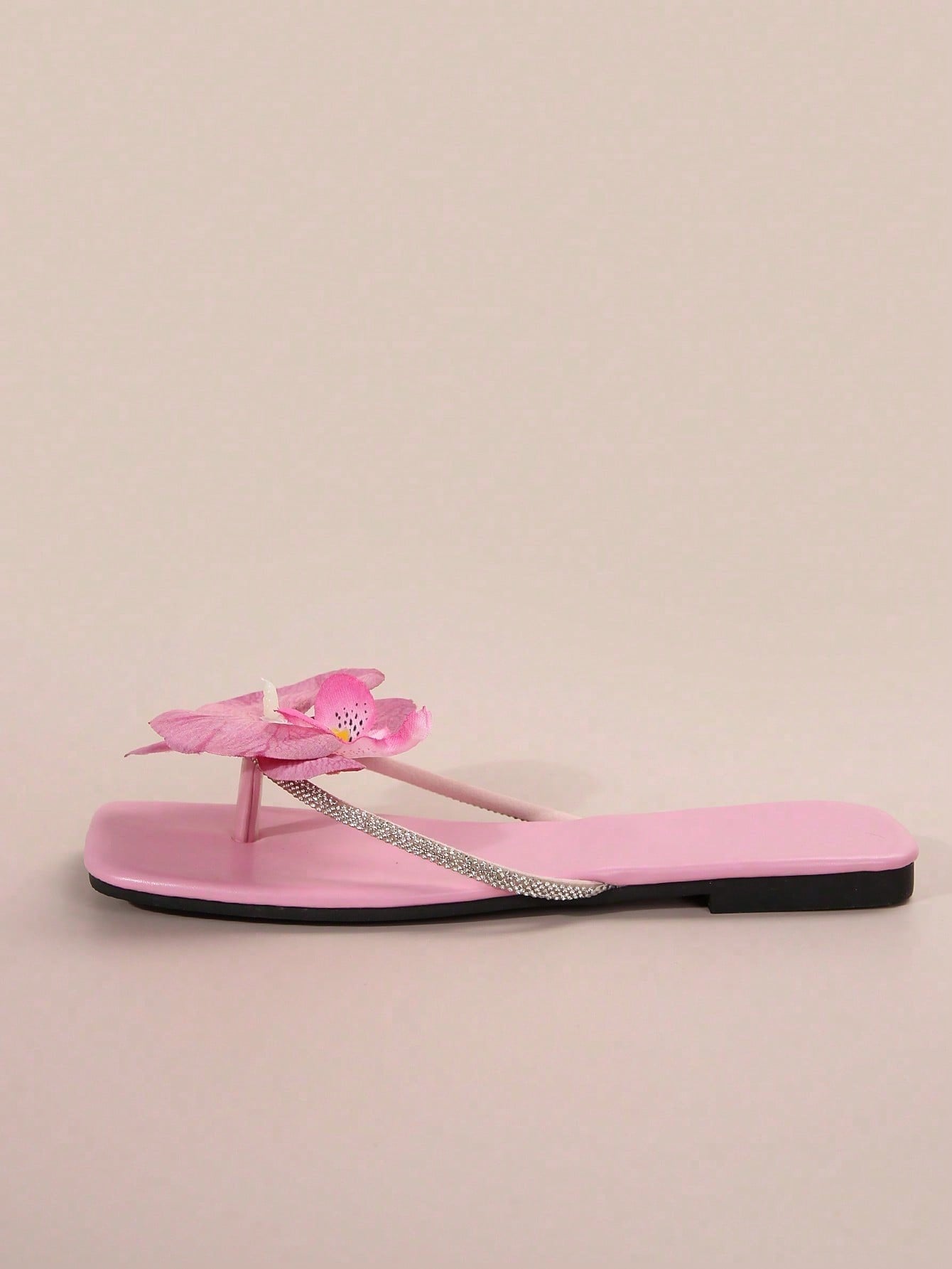Women's flat slide sandals with open toe, floral applique detail, and criss-cross straps, shown as casual vacation-style summer footwear.