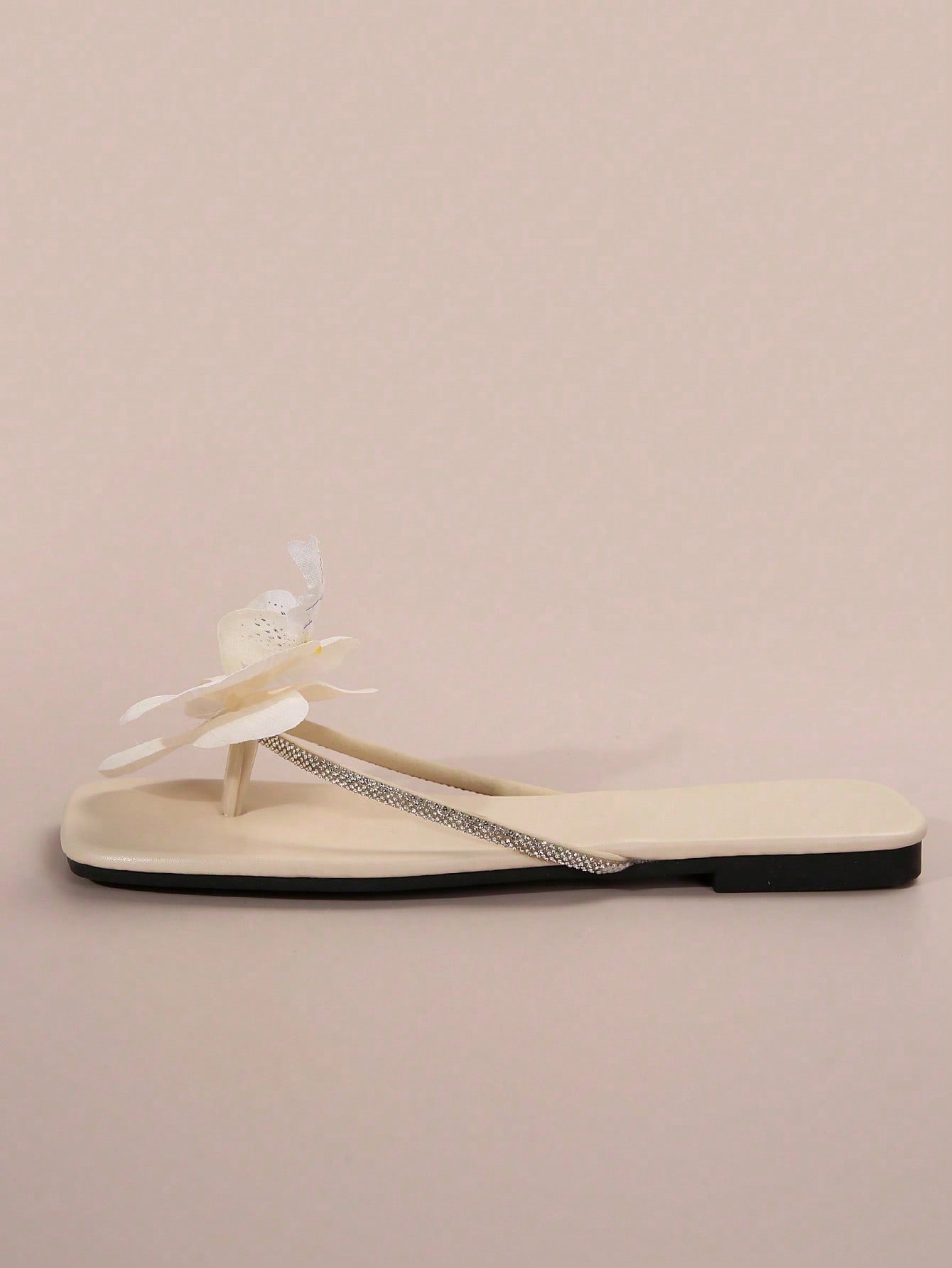 Women's flat slide sandals with open toe, floral applique detail, and criss-cross straps, shown as casual vacation-style summer footwear.