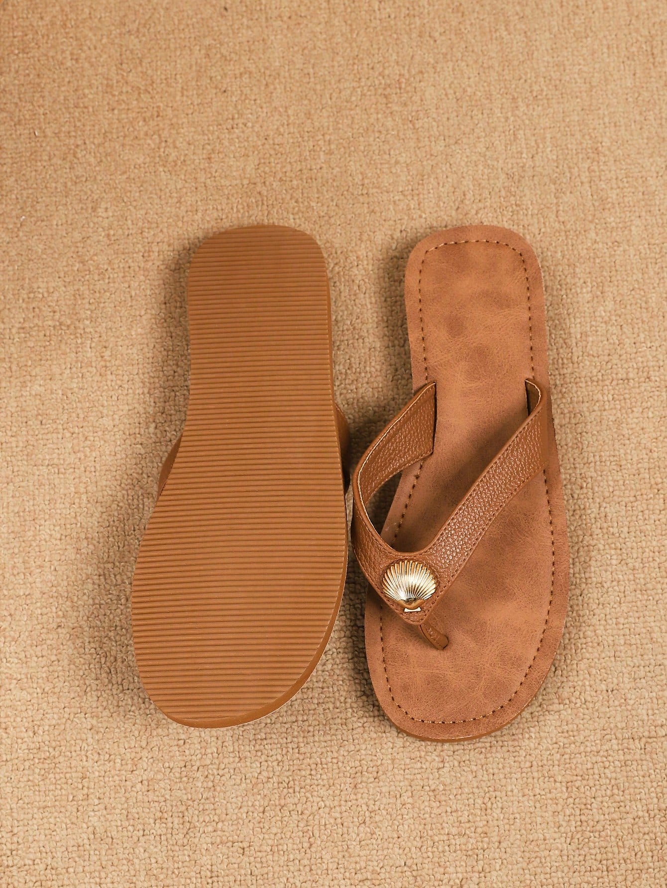 Brown vintage chic flip flops with metal shell decor, toe-post slide design, criss cross straps, and wedge sole for casual beach and outdoor wear.