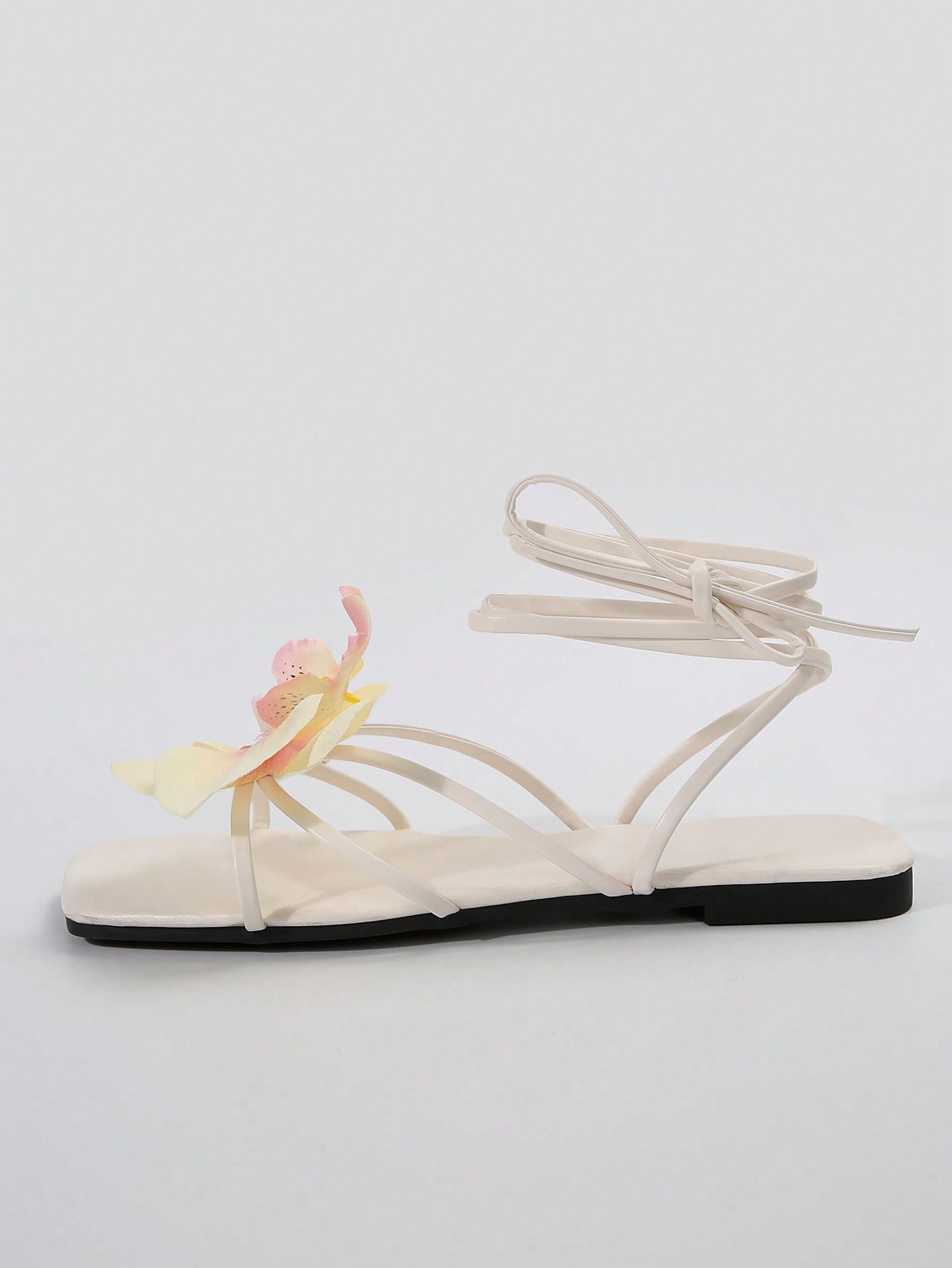 Women's flat slide sandals with open toe, floral applique detail, and criss-cross straps, shown as casual vacation-style summer footwear.