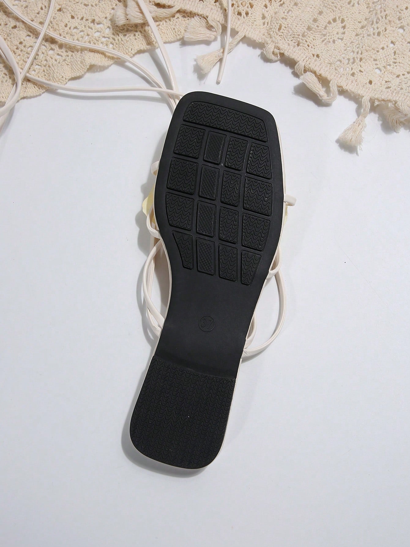 Women's flat slide sandals with open toe, floral applique detail, and criss-cross straps, shown as casual vacation-style summer footwear.