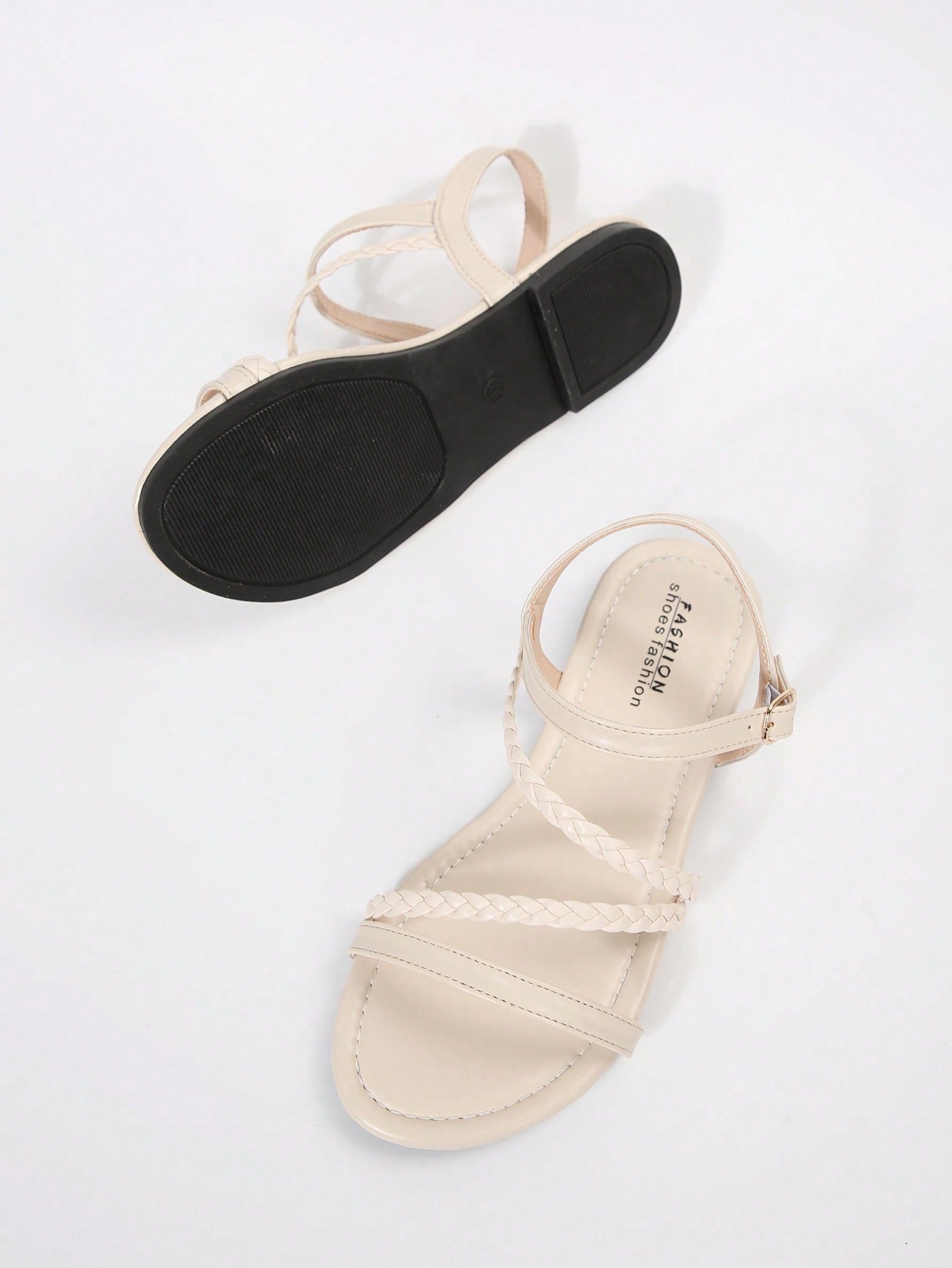 Pair of women’s plus size flat gladiator sandals with woven braid straps, snake pattern look, and open toe design.