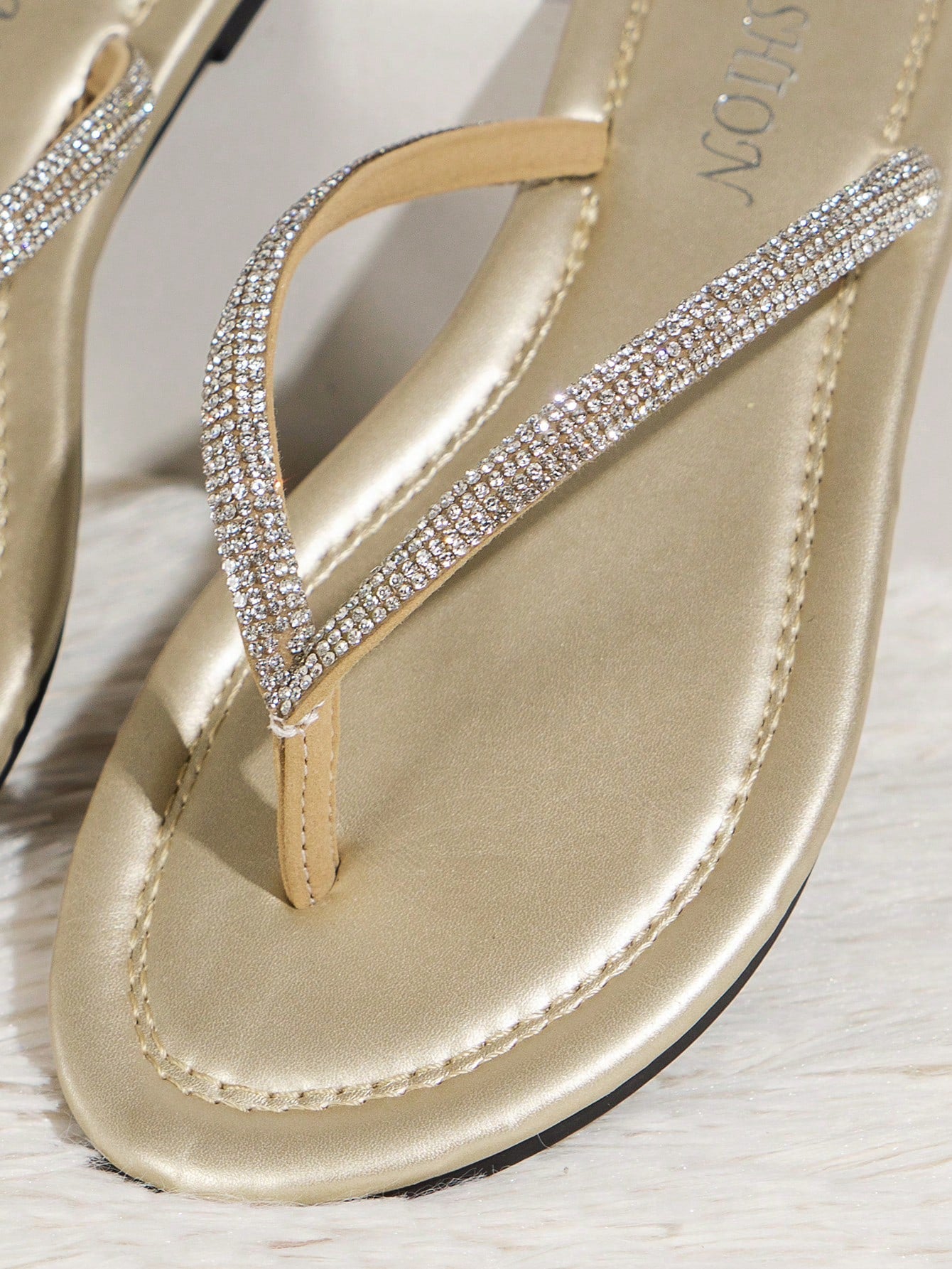 Women’s champagne flat thong slide sandals with rhinestone detail, plain pattern, and open-toe beach-ready style.