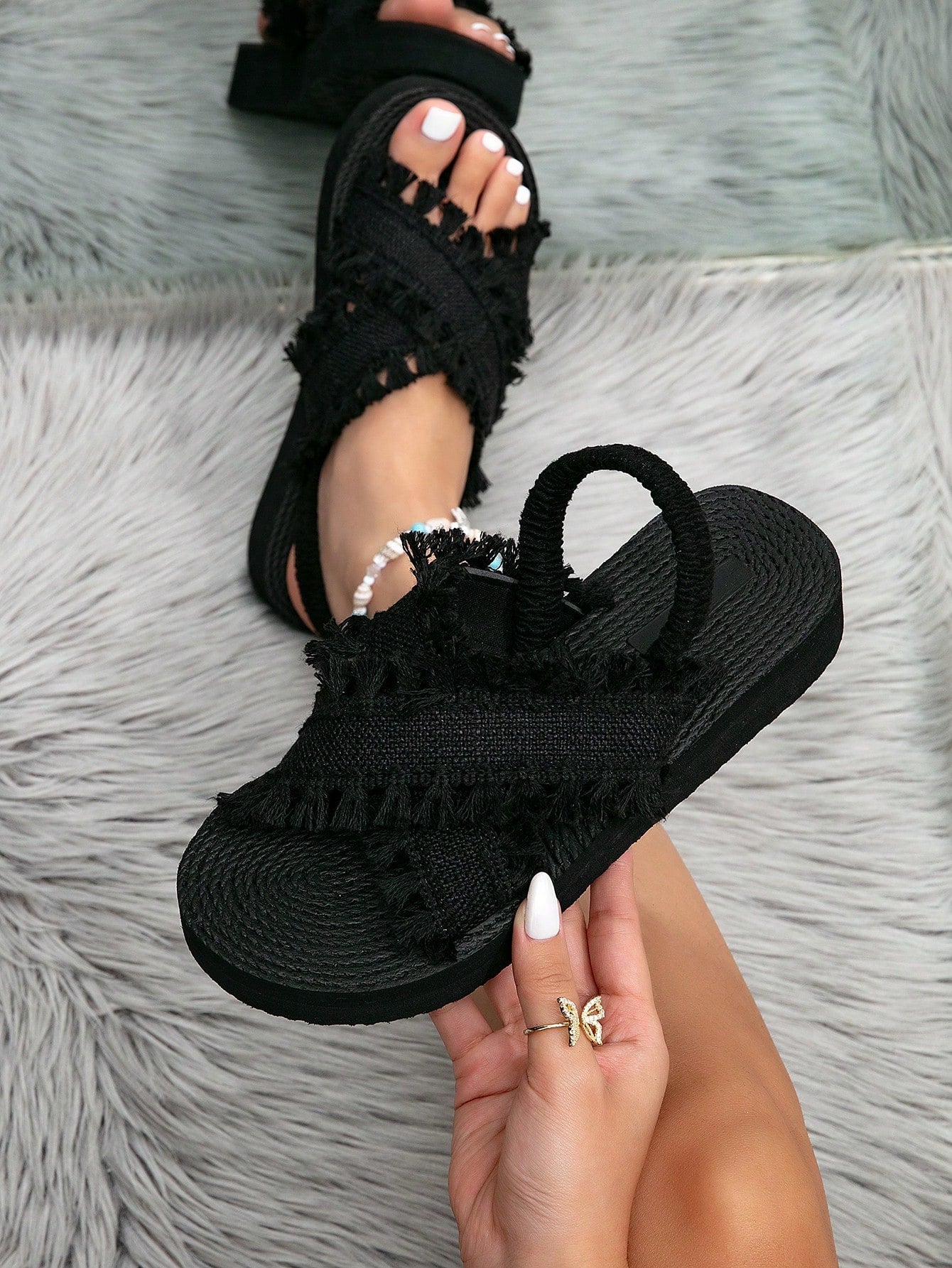 Women's open toe slip-on wedge sandals with criss cross straps and folk-custom styling, featuring raw hem, fringe, tassel, braid, and tape details.