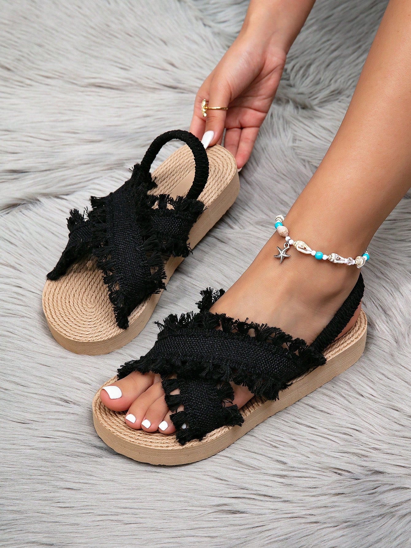 Women's open toe slip-on wedge sandals with criss cross straps and folk-custom styling, featuring raw hem, fringe, tassel, braid, and tape details.