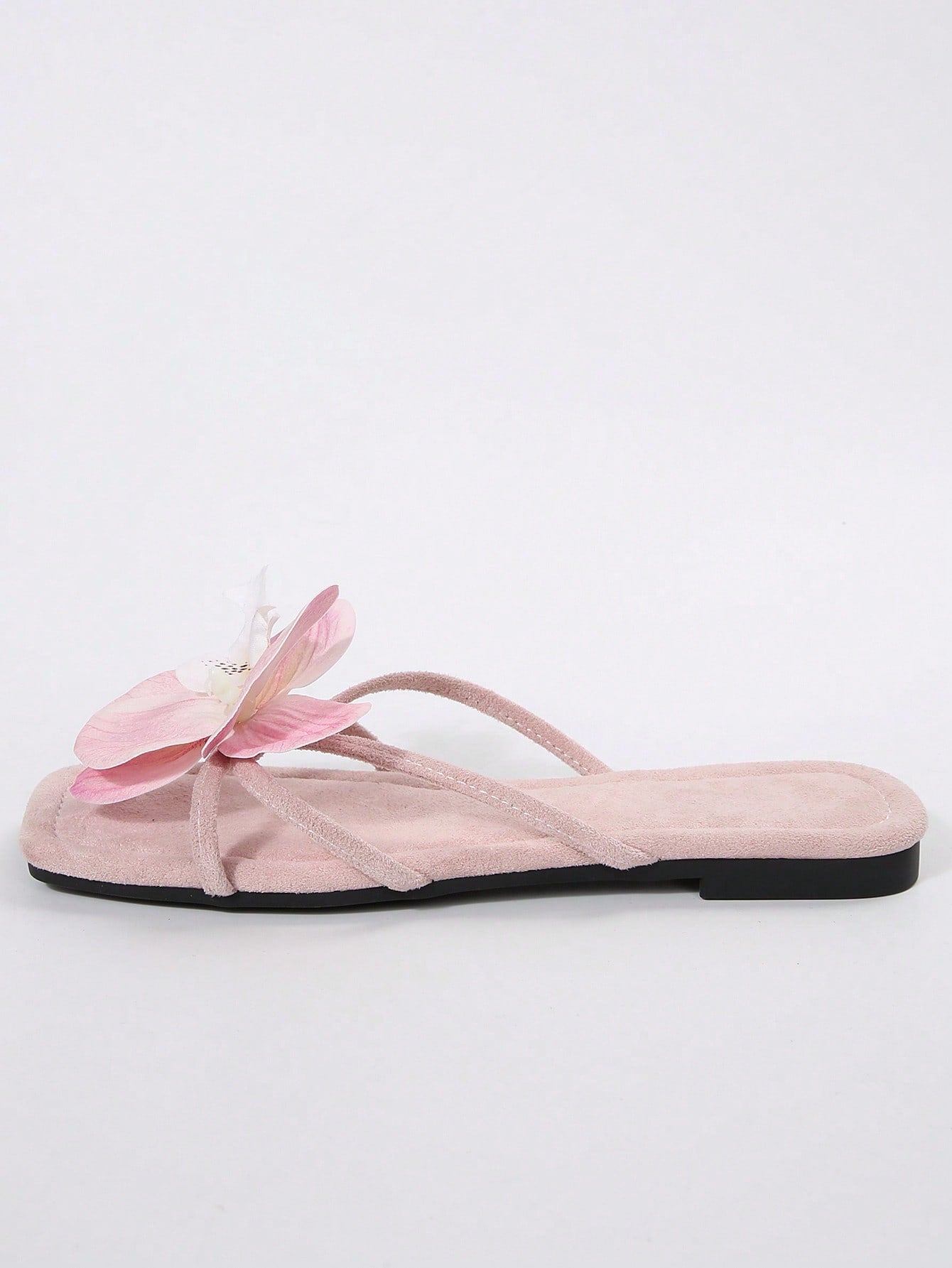 Women's flat slide sandals with open toe, floral applique detail, and criss-cross straps, shown as casual vacation-style summer footwear.