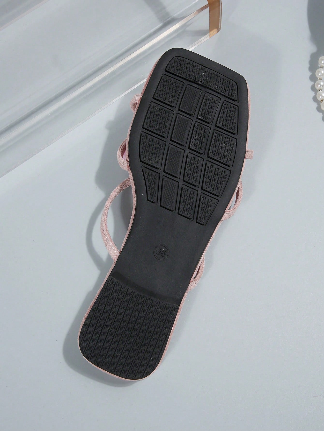 Women's flat slide sandals with open toe, floral applique detail, and criss-cross straps, shown as casual vacation-style summer footwear.