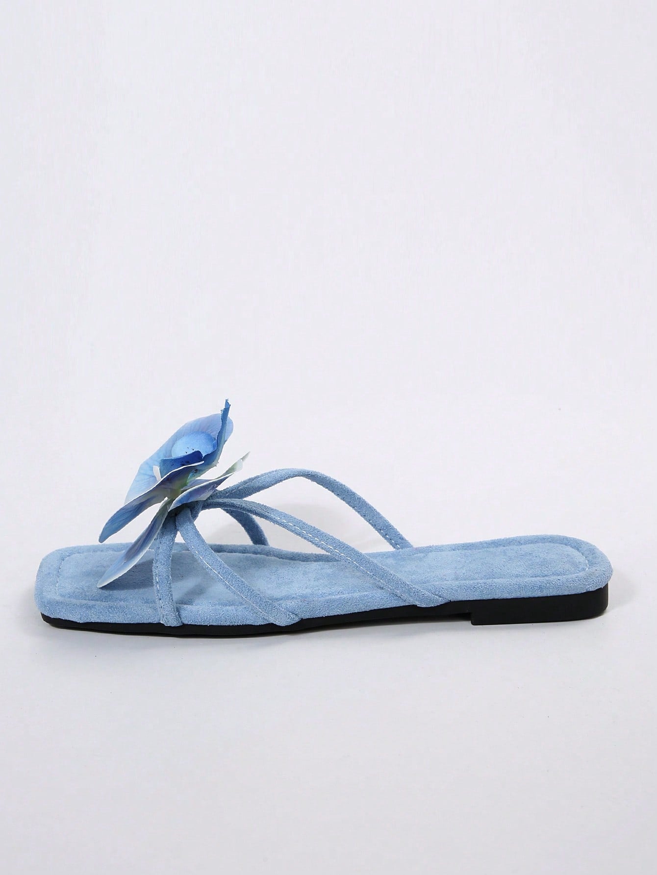 Women's flat slide sandals with open toe, floral applique detail, and criss-cross straps, shown as casual vacation-style summer footwear.