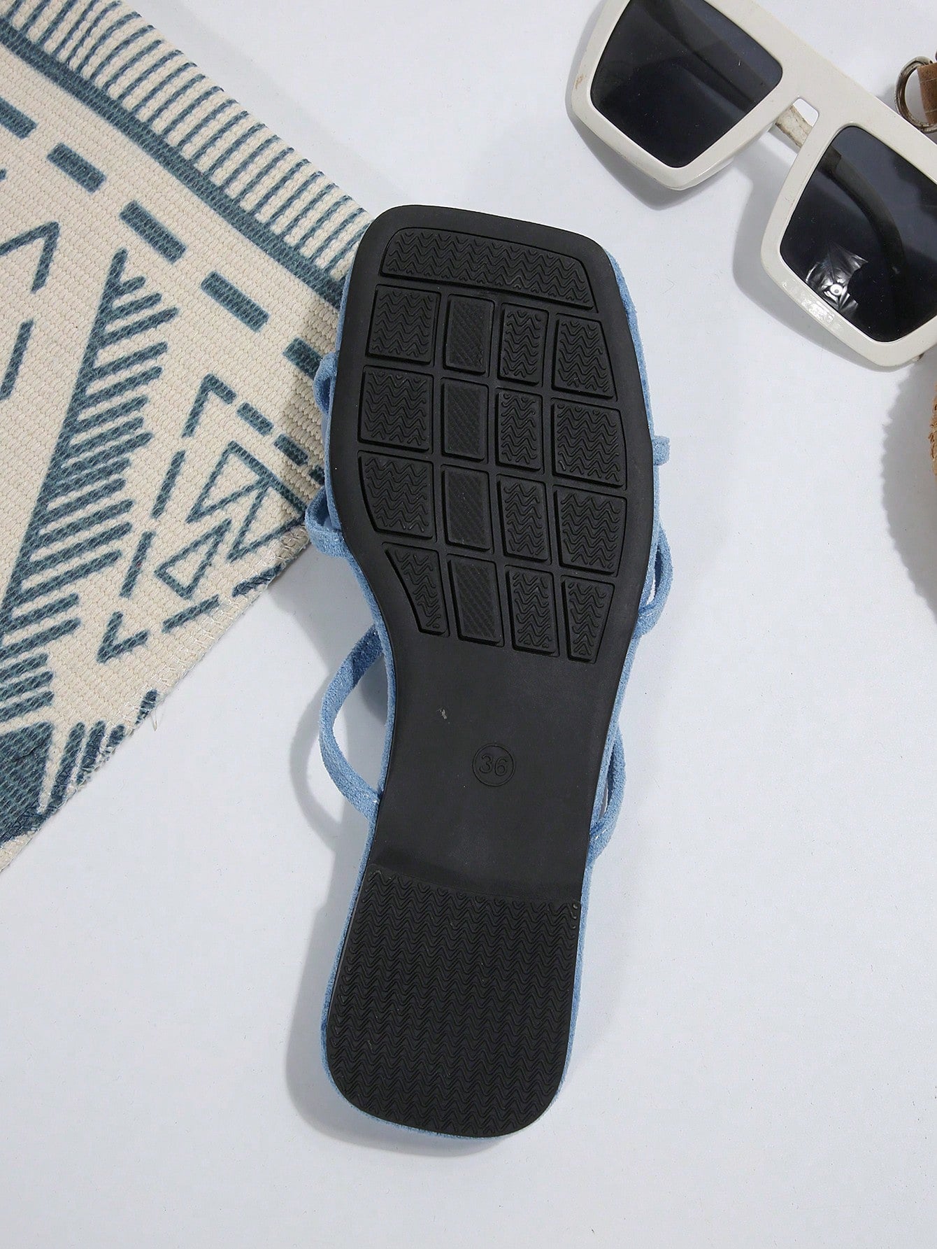 Women's flat slide sandals with open toe, floral applique detail, and criss-cross straps, shown as casual vacation-style summer footwear.