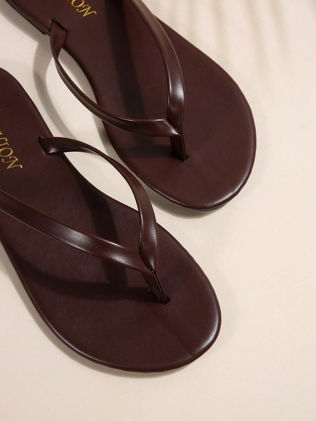 Women's chocolate brown flat flip flop sandals featuring a toe-post thong style and braided detail, suitable for casual indoor and outdoor wear.