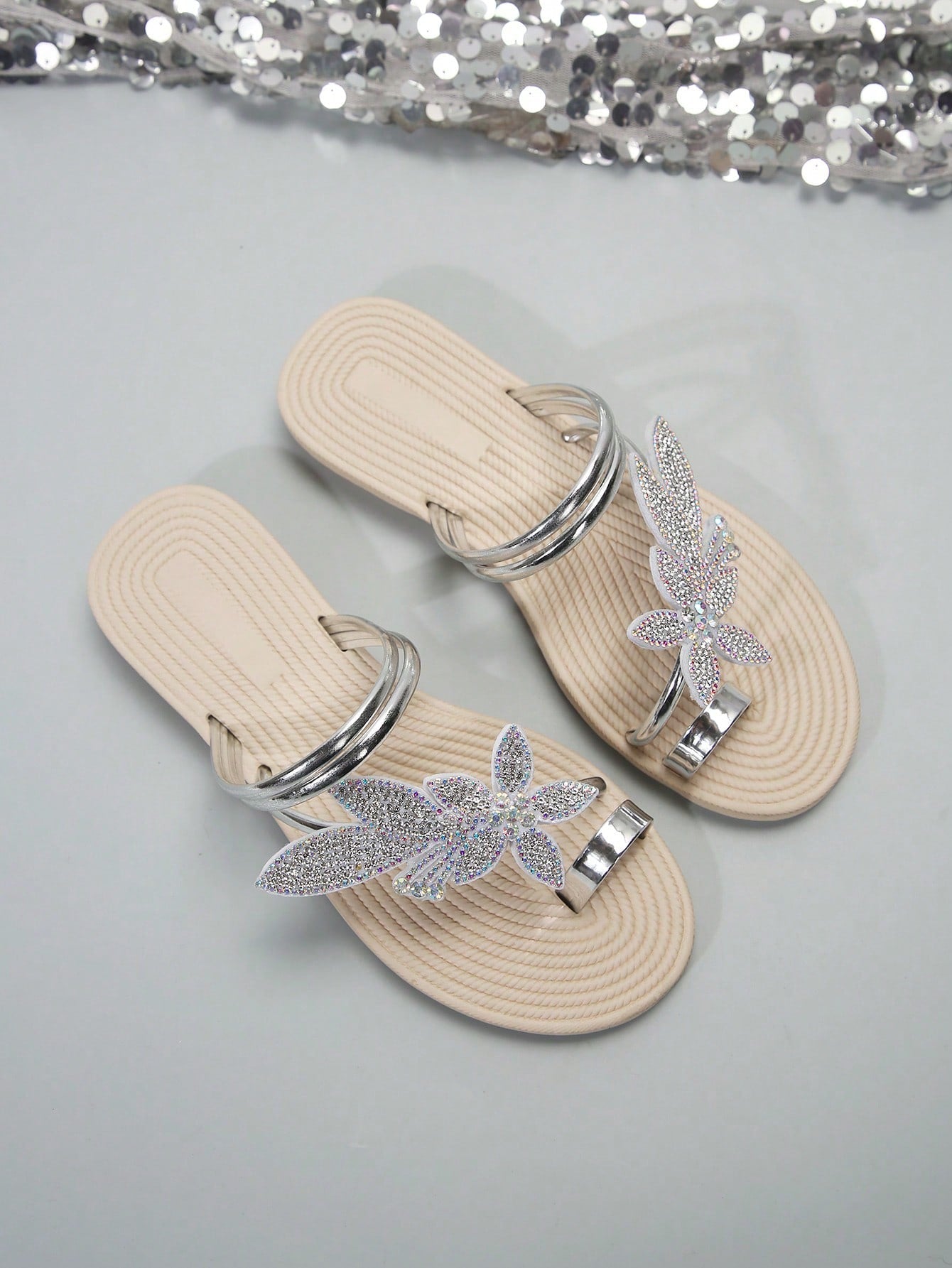 Women's flat slide sandals with crystal-style rhinestone and bow embellishments, toe post front, and beach-ready slip-on design.
