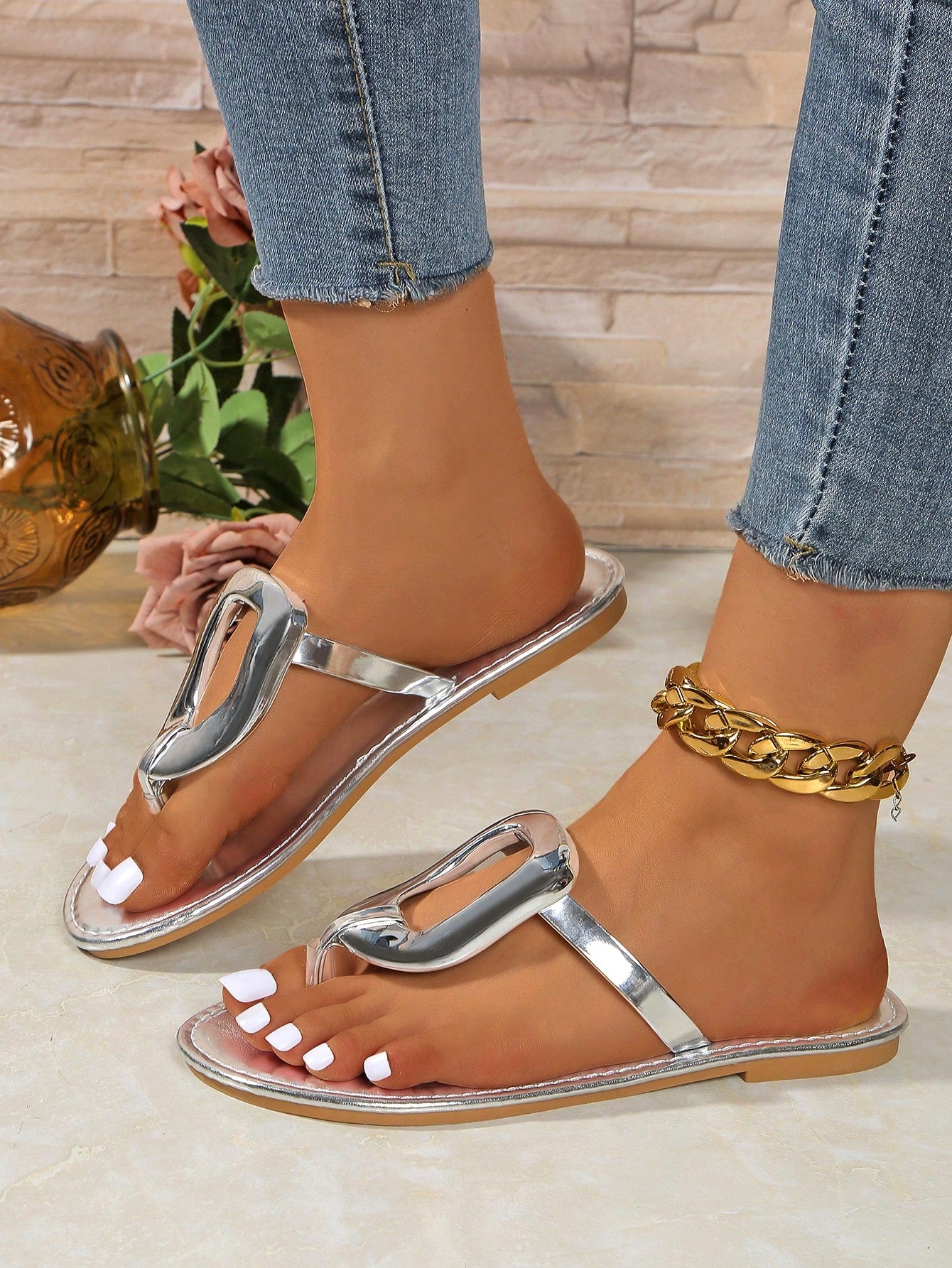 Women’s gold flat slide sandals with open toe post design and metal buckle detail, shown as fashionable outdoor summer footwear.