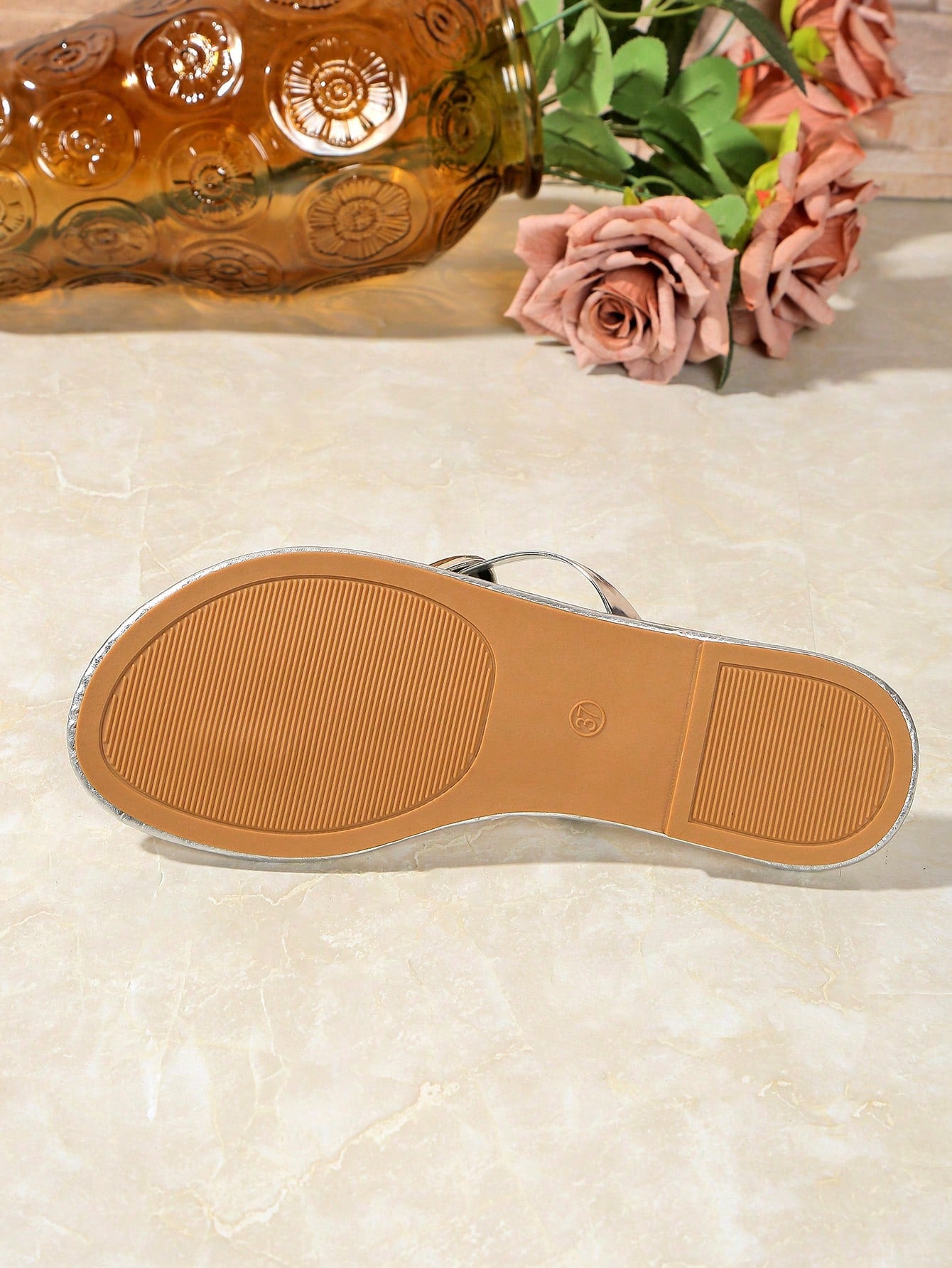 Women’s gold flat slide sandals with open toe post design and metal buckle detail, shown as fashionable outdoor summer footwear.