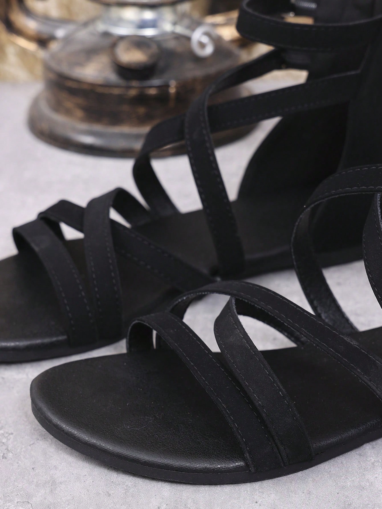 Women's black flat gladiator sandals with cross-over front straps, open toe design, and zipper back strap in a vintage casual beach style.