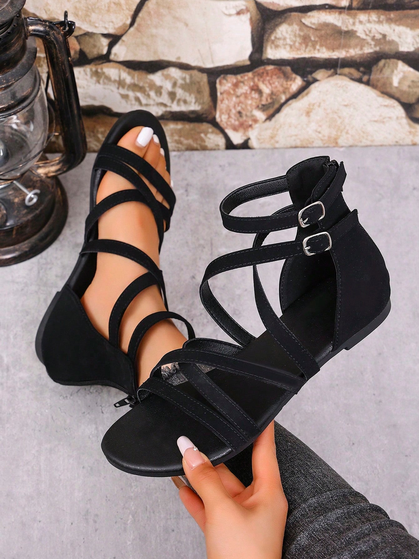 Women's black flat gladiator sandals with cross-over front straps, open toe design, and zipper back strap in a vintage casual beach style.