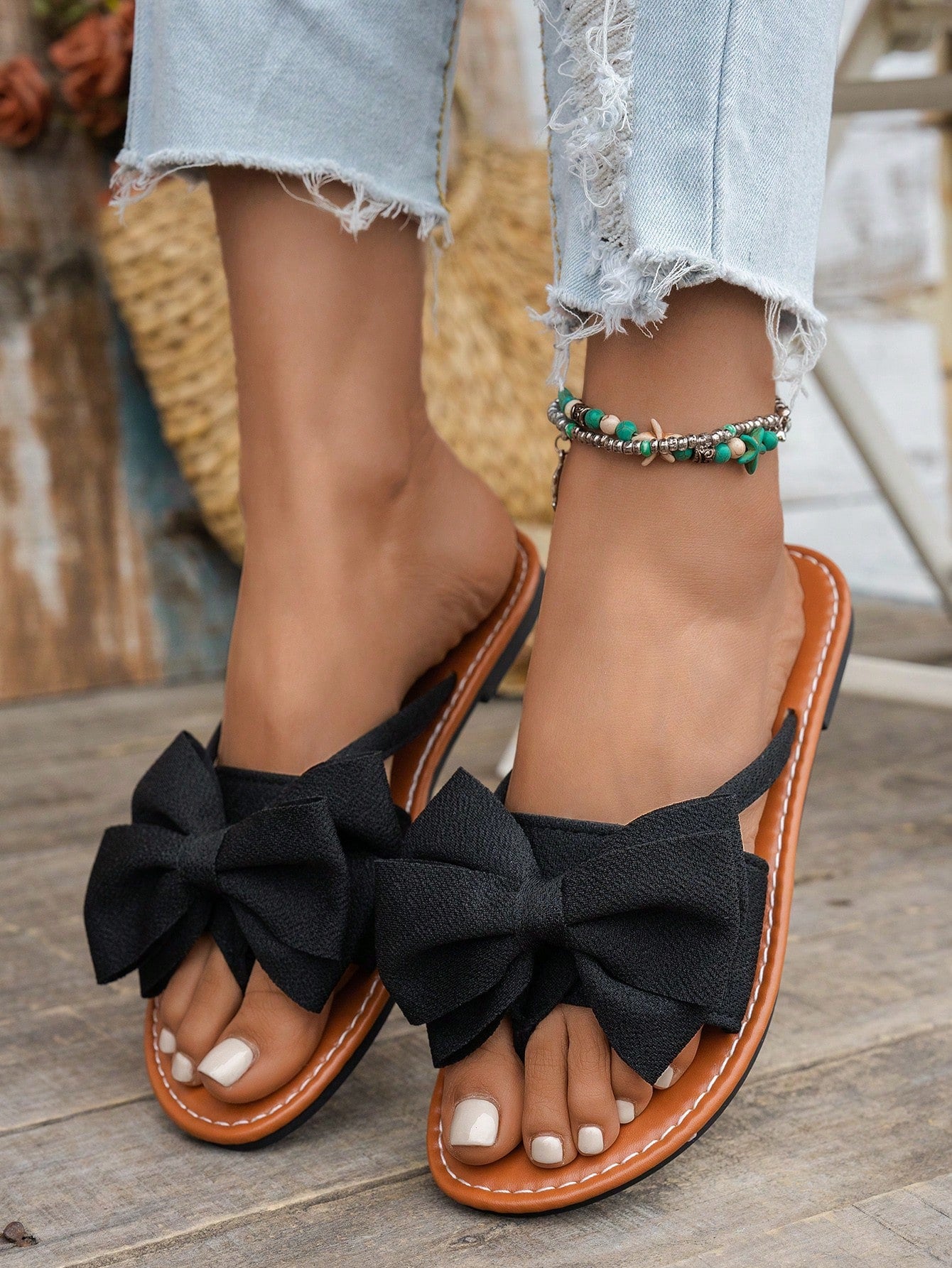 Women's flat bow thong sandals in a casual beach slide style with open toe and tropical pattern.
