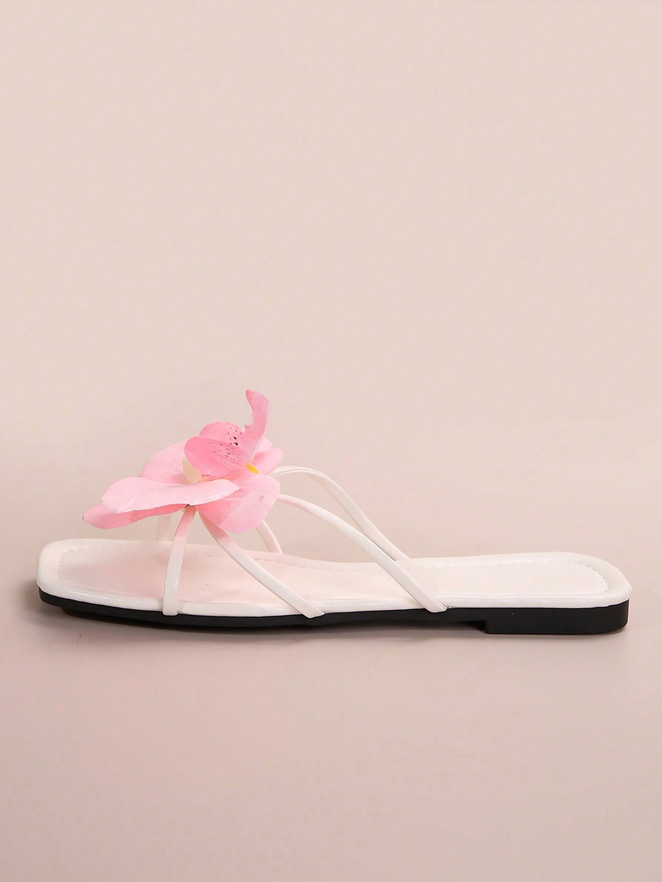 Women's flat slide sandals with open toe, floral applique detail, and criss-cross straps, shown as casual vacation-style summer footwear.