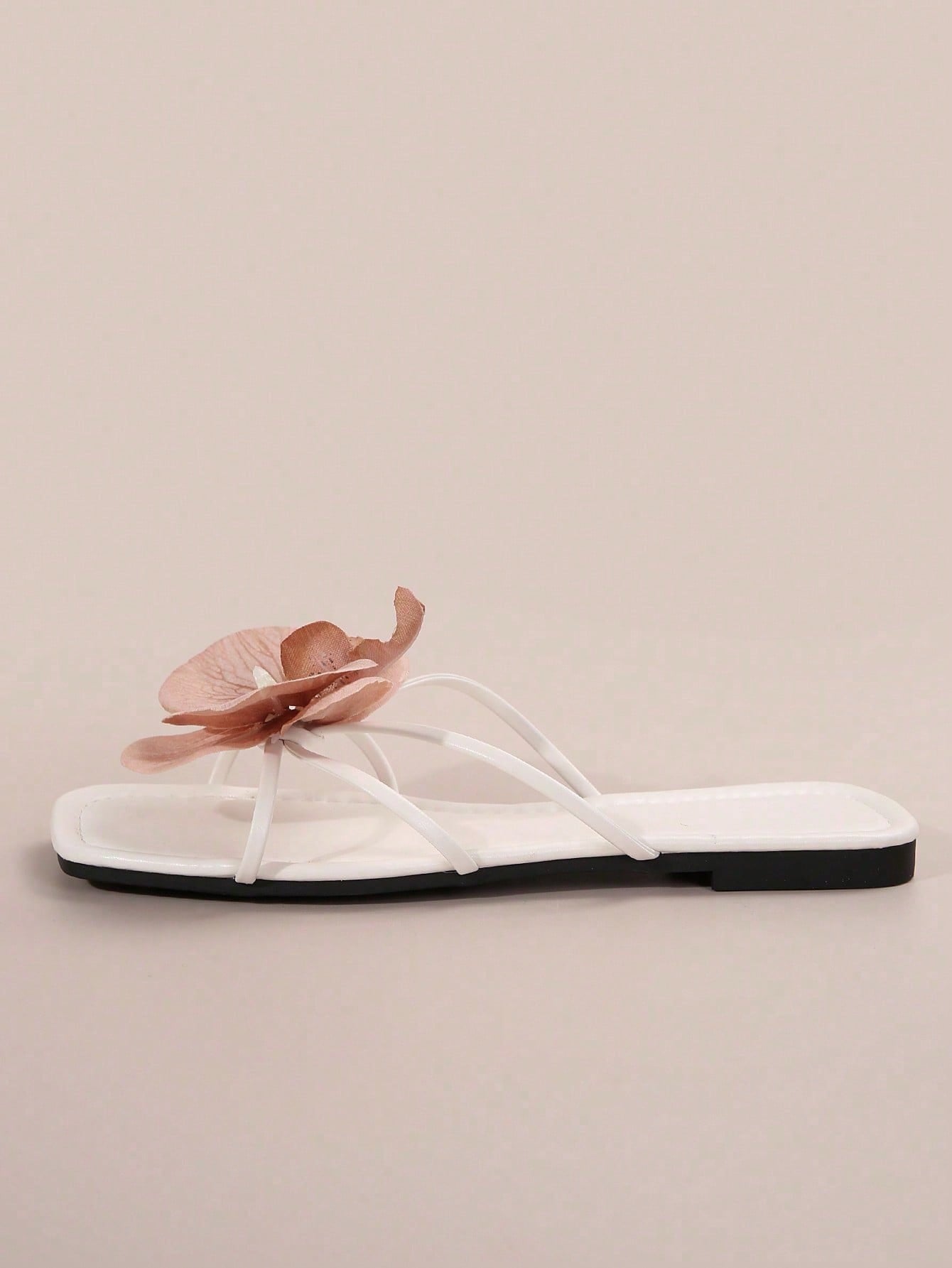 Women's flat slide sandals with open toe, floral applique detail, and criss-cross straps, shown as casual vacation-style summer footwear.