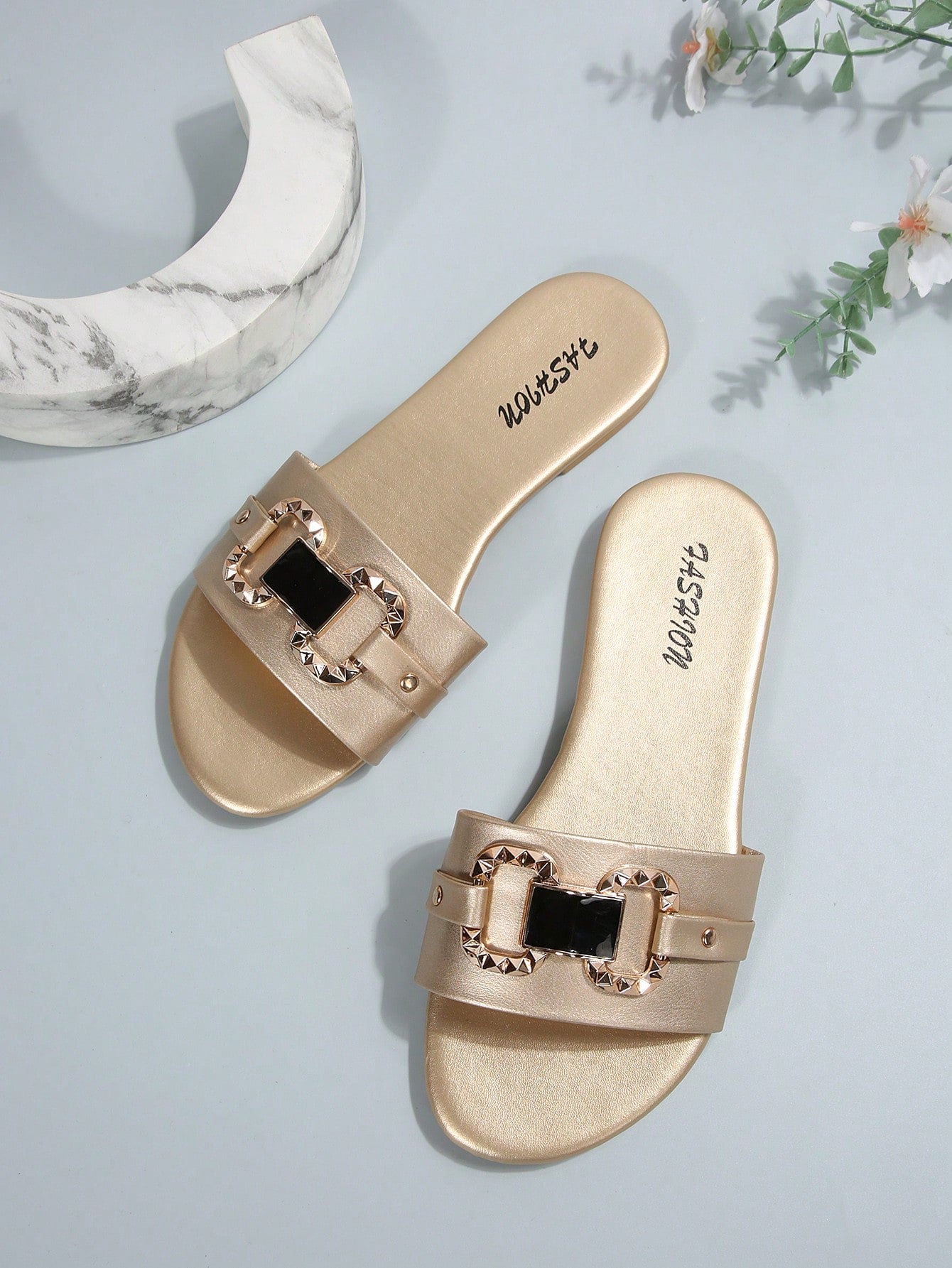 Pair of women's black flat slide sandals featuring rhinestone embellishments, metal accents, and a gold-strip detail on the upper, with an open-toe slip-on design.