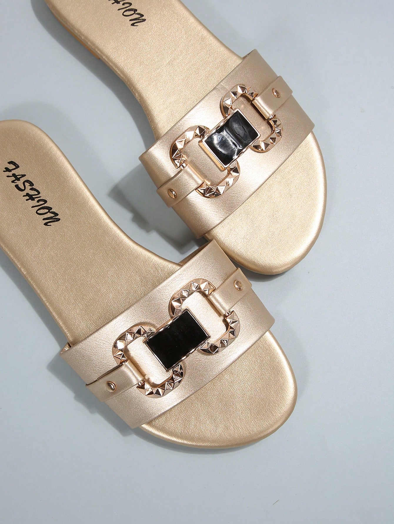 Pair of women's black flat slide sandals featuring rhinestone embellishments, metal accents, and a gold-strip detail on the upper, with an open-toe slip-on design.
