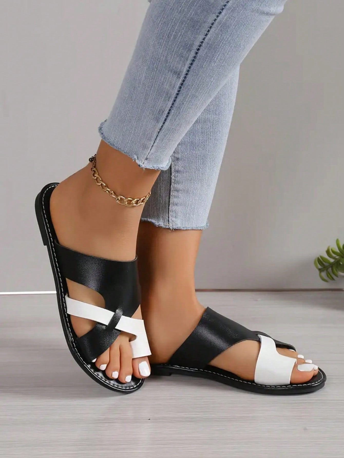 Women’s plus size flat slide sandals with toe-post front and cross-over patchwork upper, designed for casual outdoor and vacation wear.
